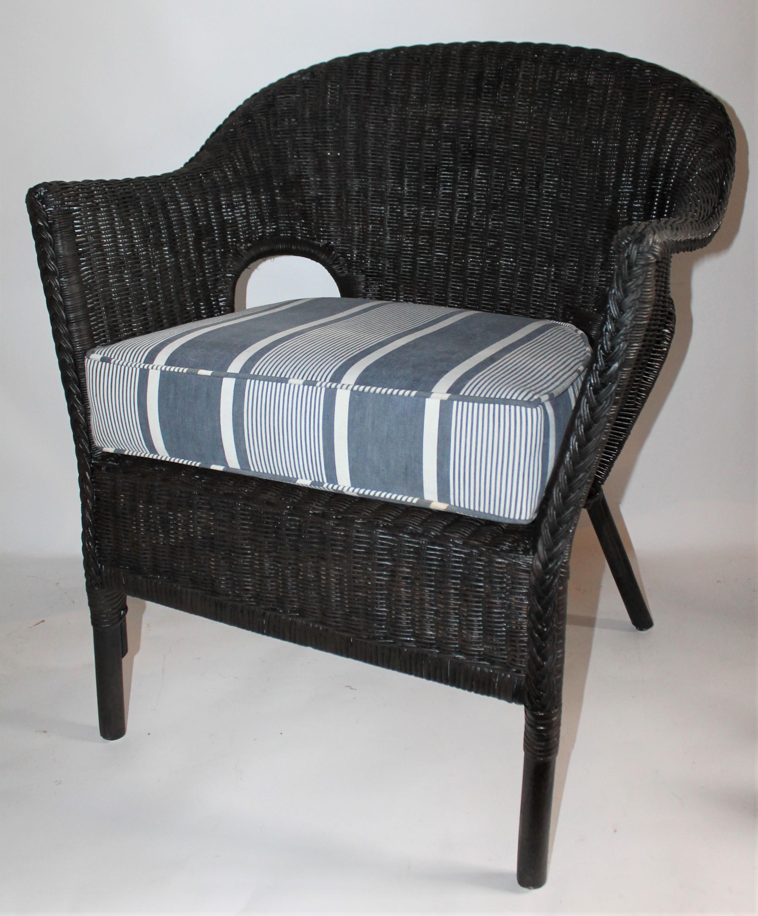 This fine tightly woven wicker chair in old black painted surface has a vintage black and white faded ticking cushion. This cushion is down and feather fill and has a zipper for removing for cleaning. You can hand wash the ticking cover as it is