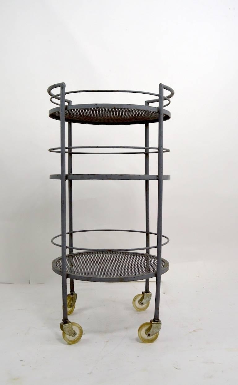 Circular three-tier wrought iron serving cart by Woodard. This example is in original battleship grey paint finish, which shows wear. Structurally sound and free of damage, cosmetic wear to finish, normal and consistent with age. Suitable for indoor