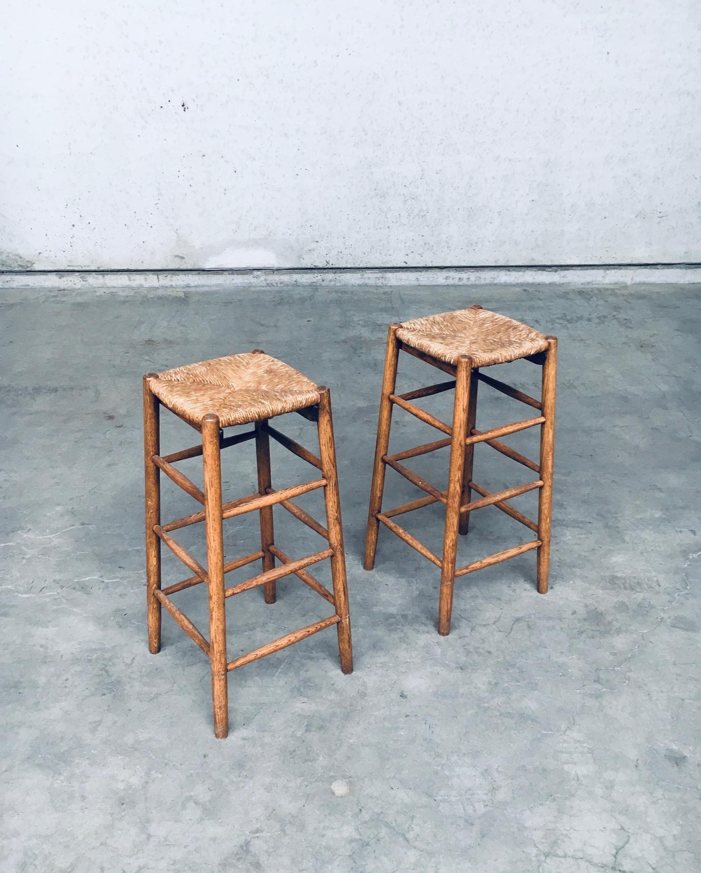 Vintage Mid-Century French Rustic made Bar Stool set in the style of Charlotte Perriand. Made in France, 1950's / 1960's period. Solid oak constructed frame with rush woven seat. Nice tapering in the design with a light color varnish. Both are in