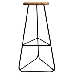 Taburete de bar con estructura de acero negro y asiento macizo de nogal