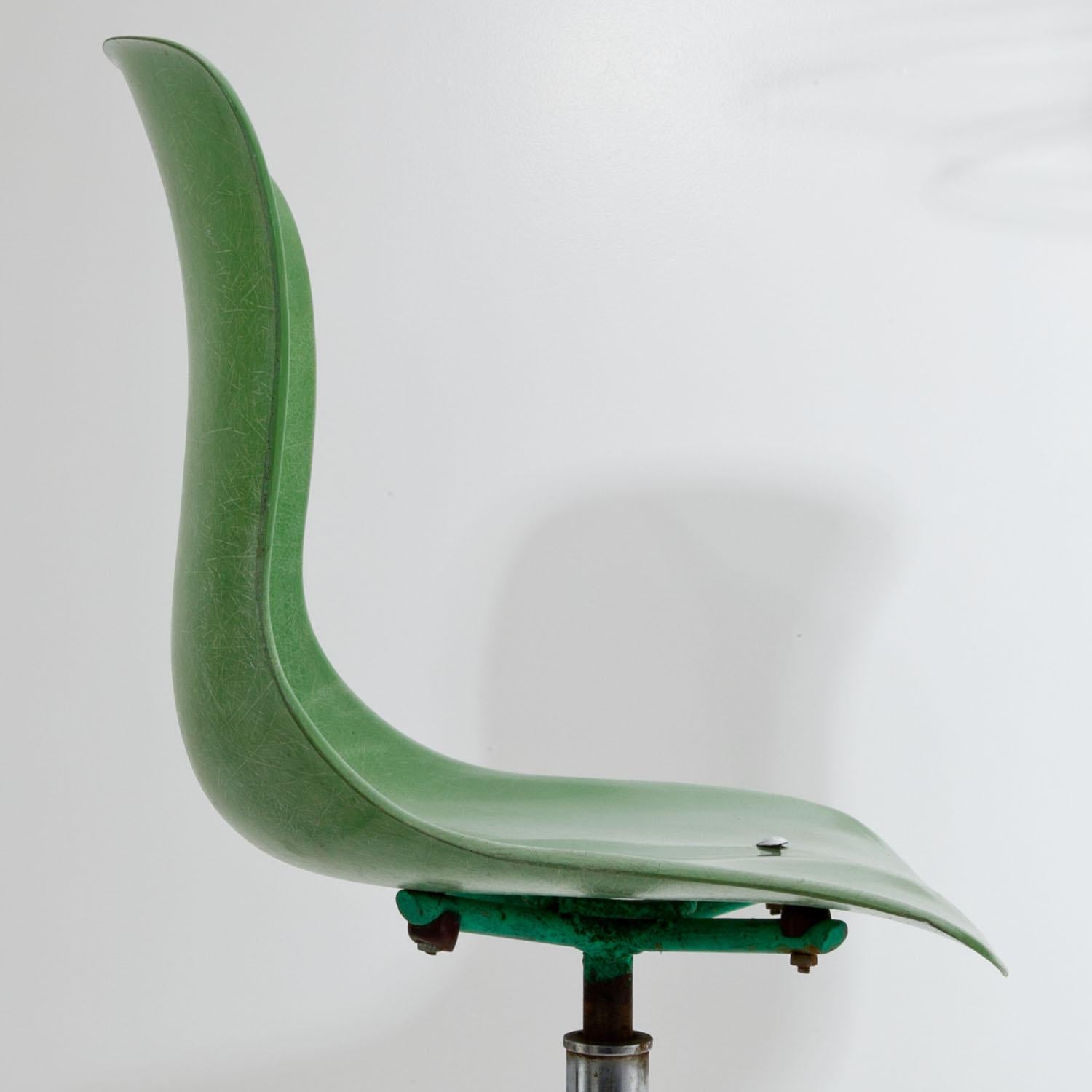 Pair of bar stools with green seats and iron legs.