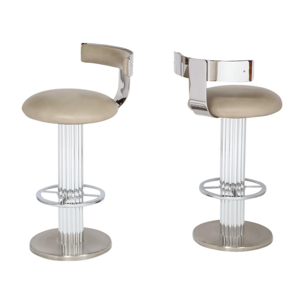 Bar stools by Designs for Leisure, chrome steel, swivel, signed. A pair of heavy swivel barstools with high polished steel backrests and foot rests, polished aluminum reeded columns and brushed steel bases. In very good original condition with very