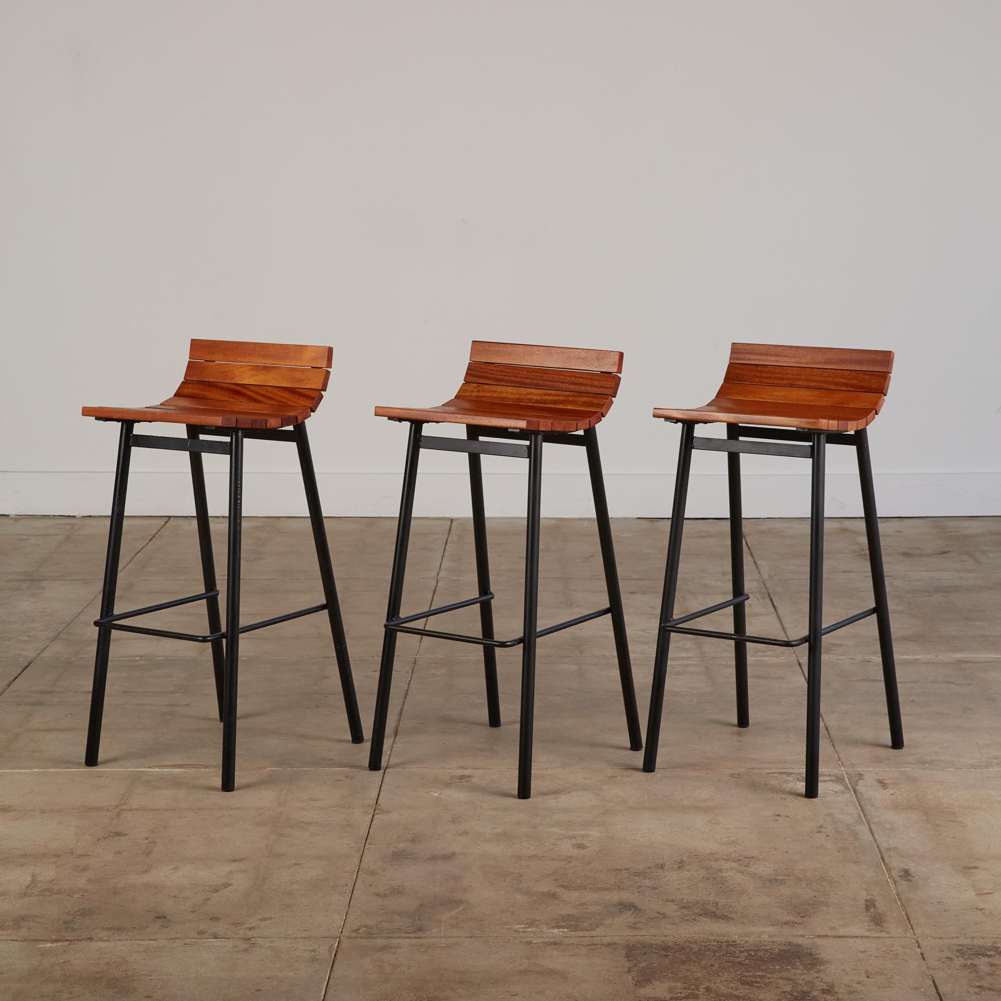 Bar stools by Vista of California, c.1950s. These bar height stools feature newly powder coated tubular steel frames with a thinner strip of steel tubing serving as a mid-height structural support as well as a footrest. The stools also feature new