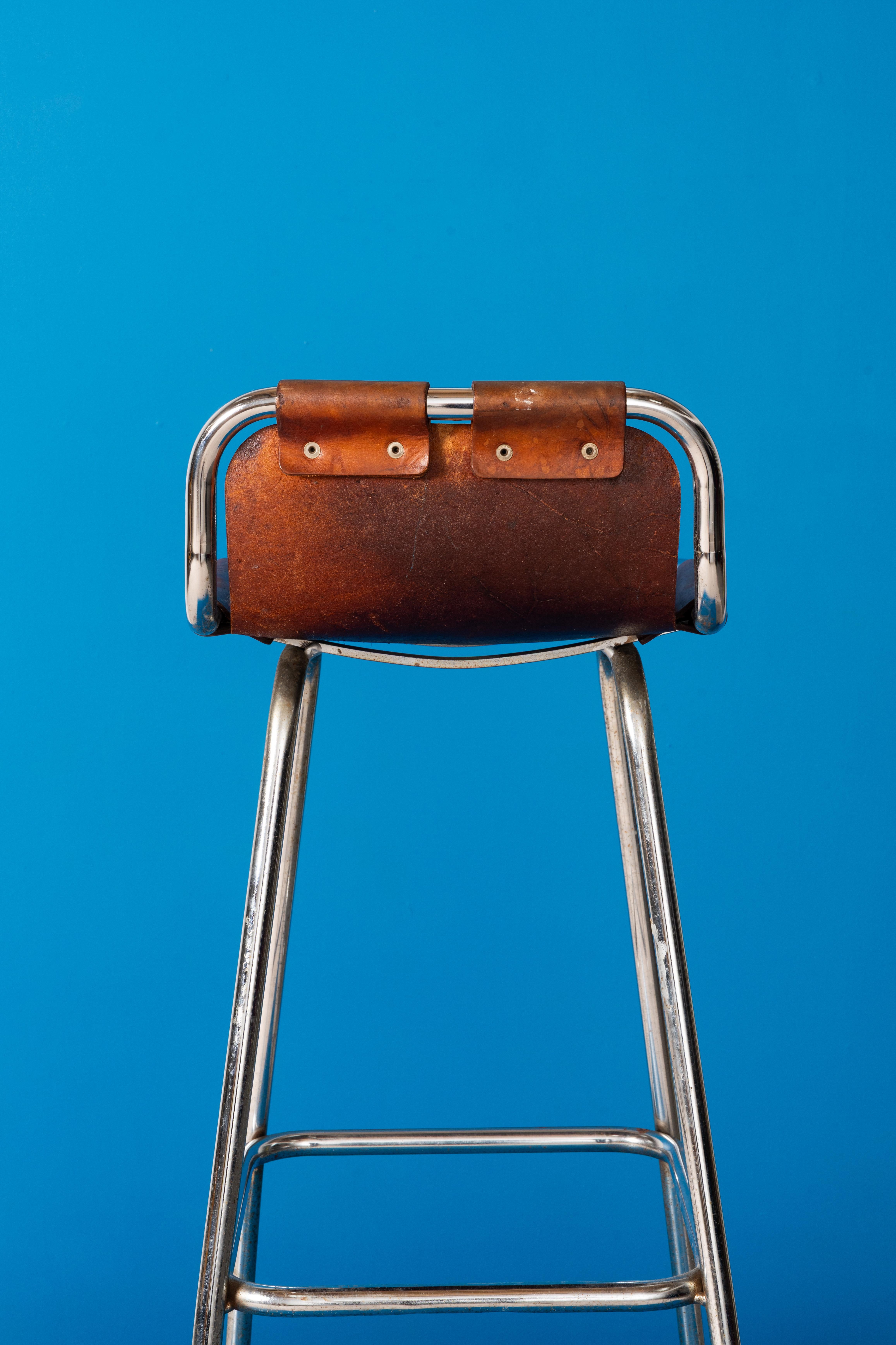 Designed by Charlotte Perriand for Les Arcs ski resort in France, 1960, these iconic stools feature an elegant combination of industrial roghness on the frame with artisanal look on the seats crafted from patinated cognac thick saddle leather,