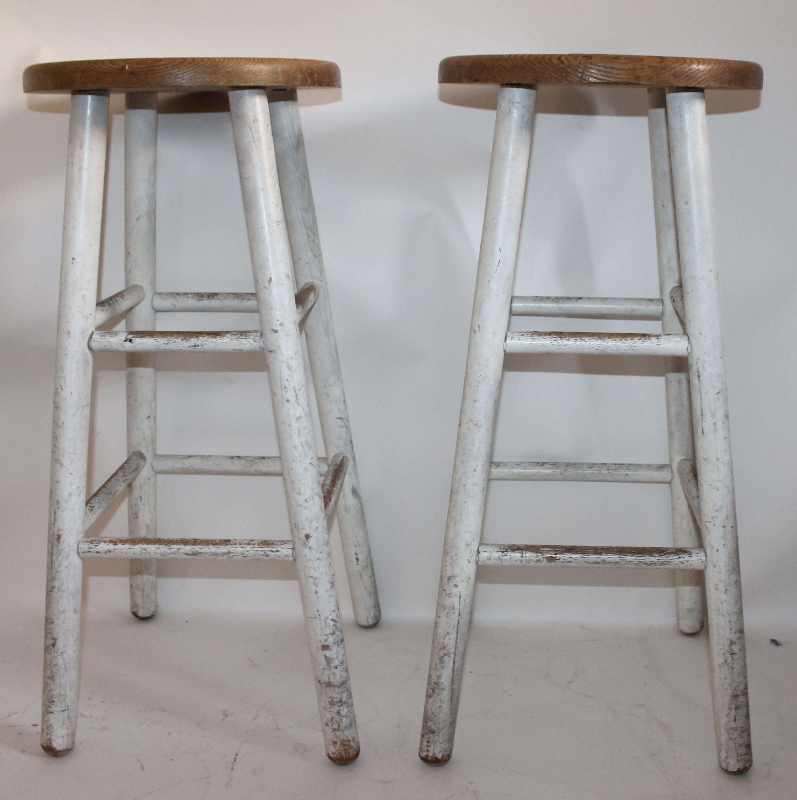 These bar stools are stamped on base from a old school room and are original white base with natural worn oak seats. These stools are so comfortable.