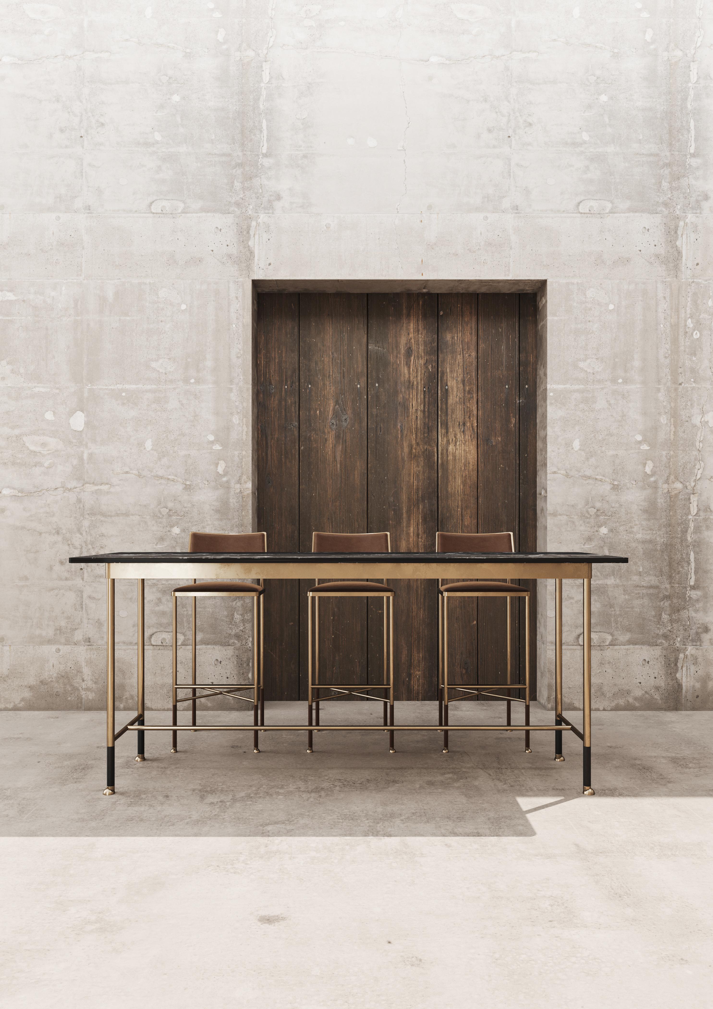 The talk to me bar table creates an opulent solution for small spaces. Designed to be beautifully unobtrusive with its slender, leather wrapped legs and minimal elegance. Featuring a stone top, brass frame and a detailed cross over bar for resting