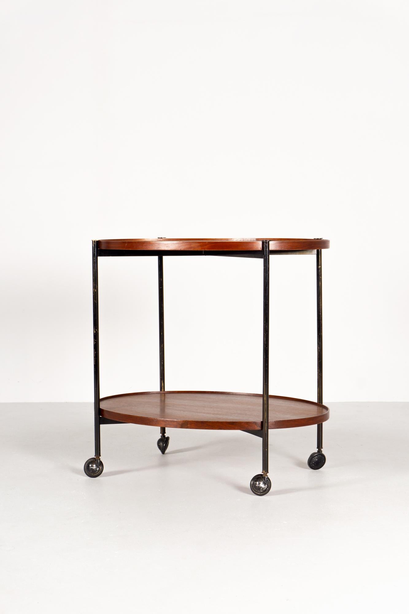Bar trolley on casters, oval, upper tray removable
Black lacquered brass construction, trays
teak wood

Paolo Tilche graduated from Milan Polytechnic in 1949. 

He immediately began working as an architect and developed both residential and
