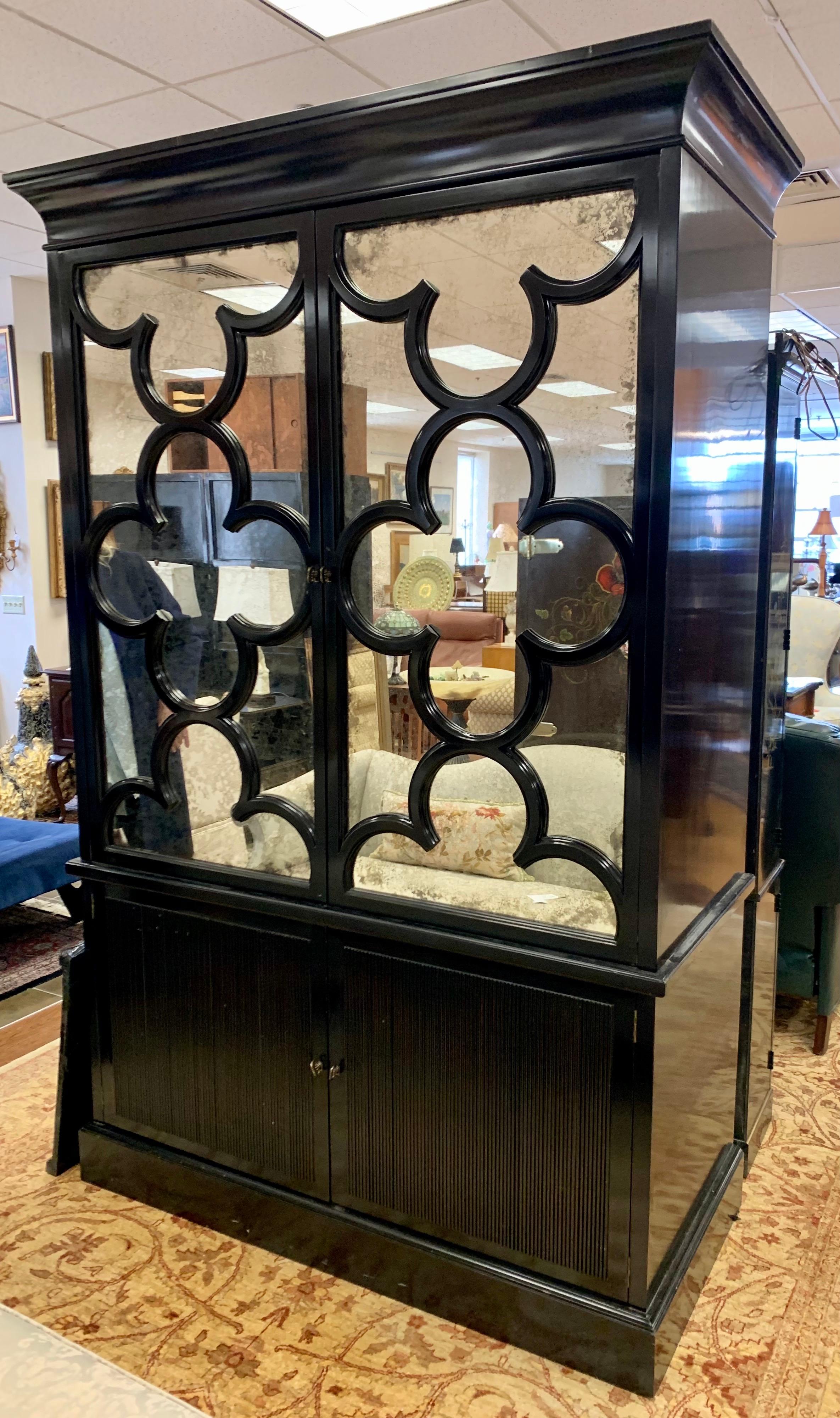 Stunning Barbara Barry for Baker Furniture 2 pc. black lacquer china cabinet with quatrefoil fretwork over mirrored doors. Mirrors have an antique finish. A great statement piece with plenty of storage for a tv or wardrobe! Retailed new a few years