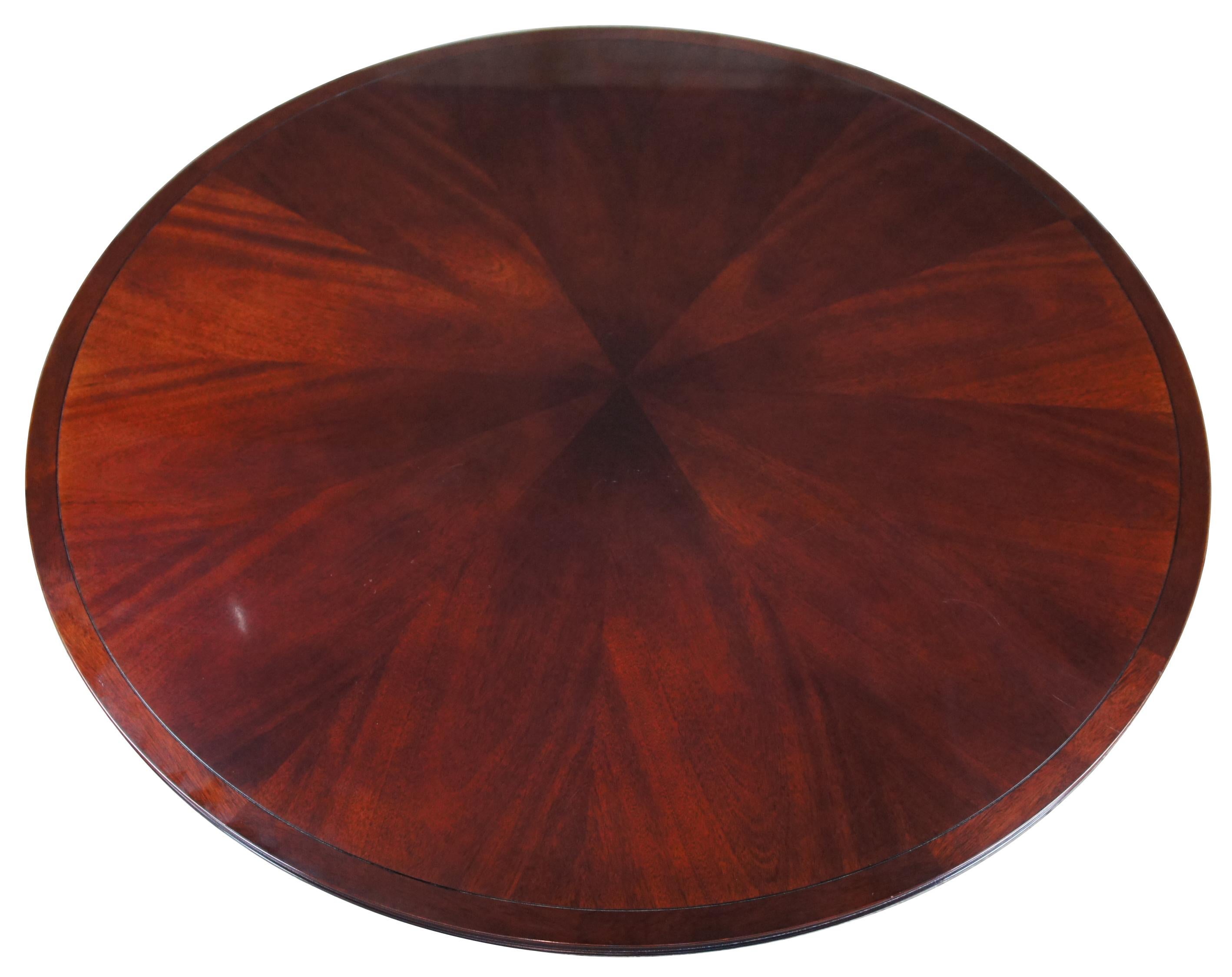 Designed by Barbara Barry for Baker, this pedestal table has a 60 inch round top with concave rim. Six curving legs are connected by a circular stretcher. The luxurious mahogany wood is covered in a rich, dark finish. Measure: 60