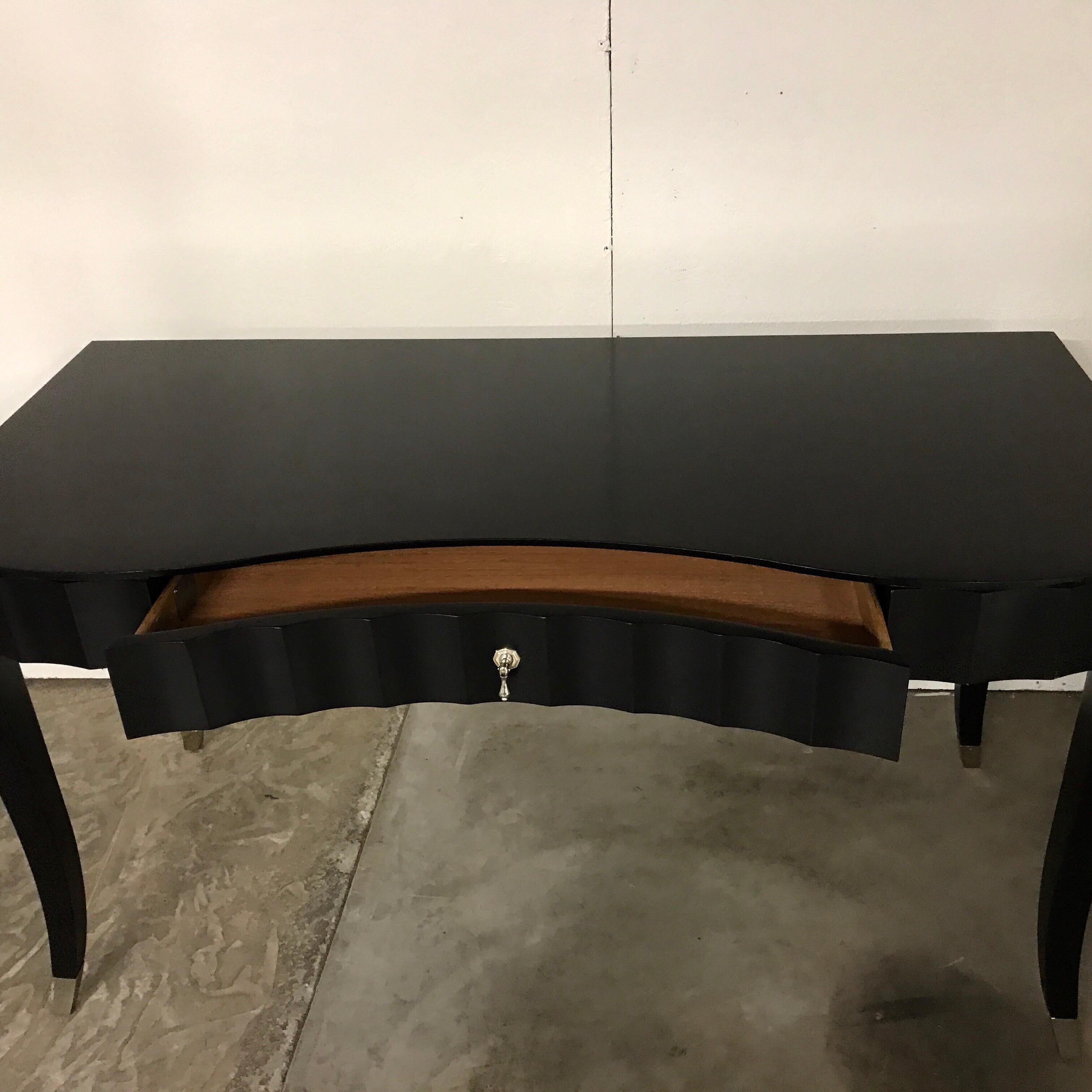 Barbara Barry for baker black lacquered desk or vanity. Beautiful black lacquer shapely case fitted with one centre drawer with silver pull and sabot fitted legs.