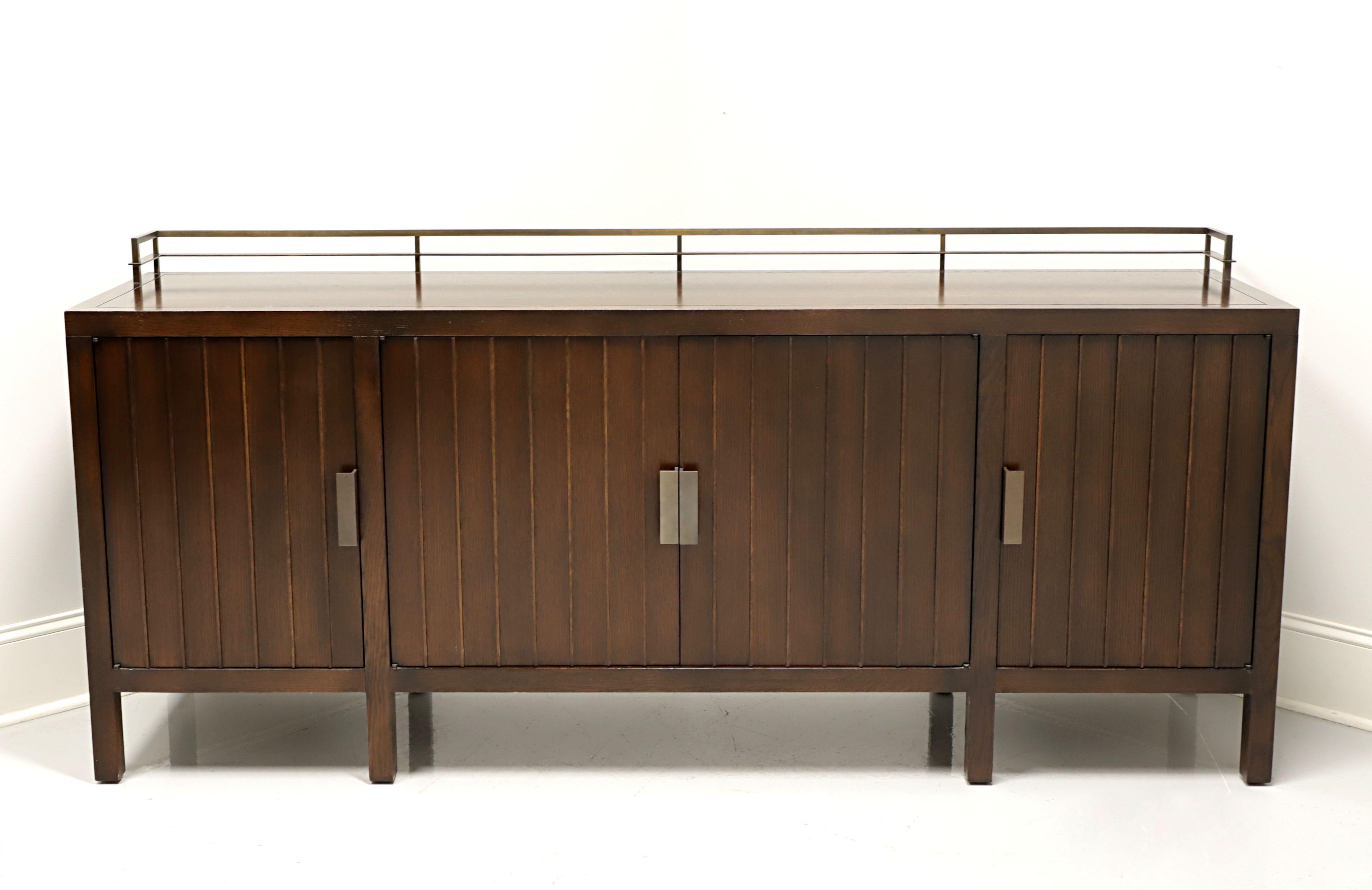 A Contemporary style sideboard by Barbara Barry for Baker Furniture. Solid mahogany, having an architectural nod with a retangular top, board banding, metal gallery, metal hardware, and a slats look to the door fronts & sides. Features two center