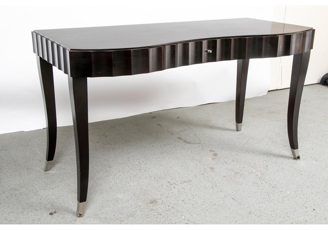 Classic Barbara Barry sinuous writing table in Espresso finish. Polished nickel drawer pull and leg caps. The metal Baker/ Barbara Barry labels are affixed to the drawer interior.
Condition: The overall condition is very good with some minor wear