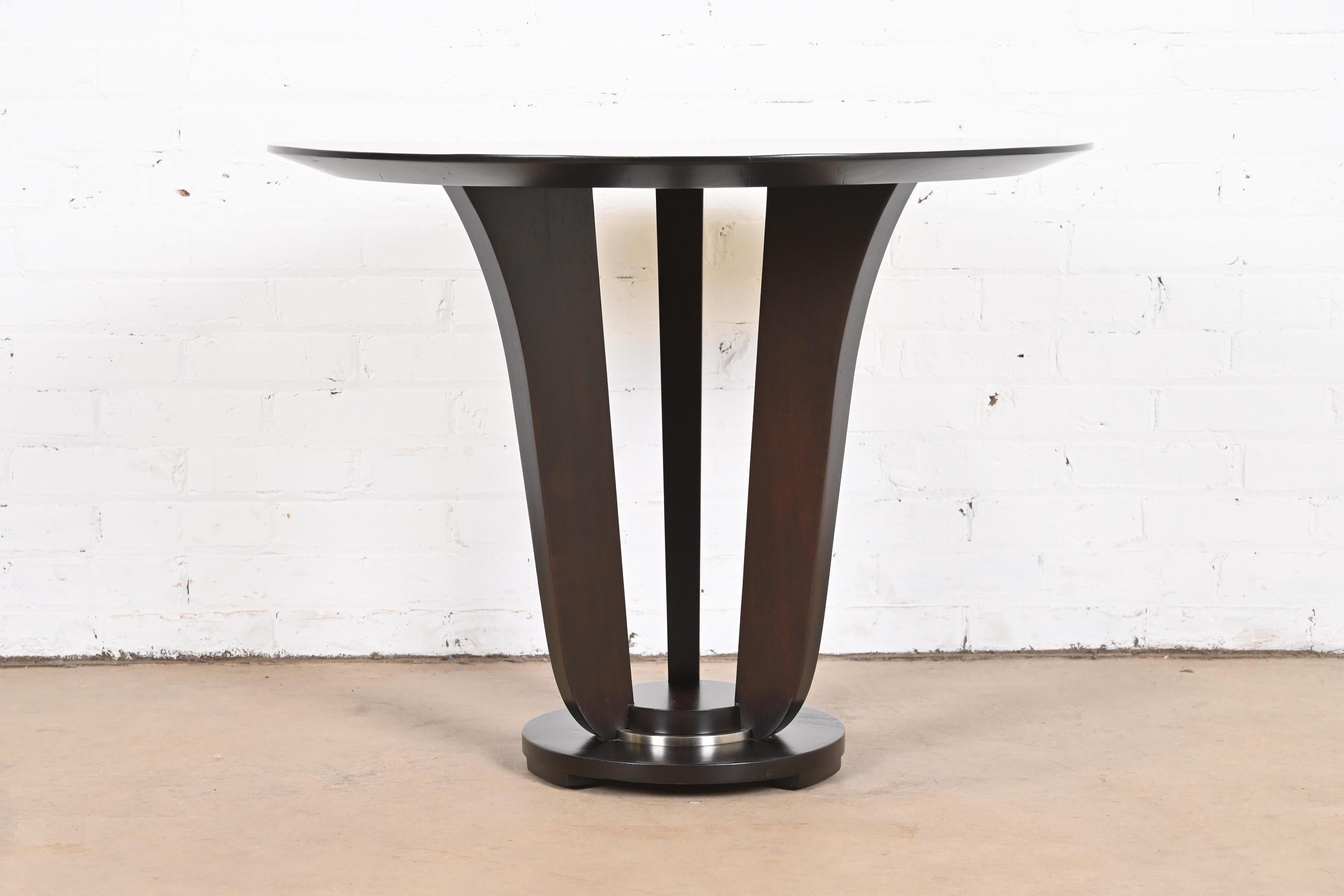 An exceptional modern Art Deco style dark mahogany pedestal center table or occasional tea table.

By Barbara Barry for Baker Furniture.

USA, circa 1990s

Material: dark mahogany, with chrome trim on base.

Measures: 32