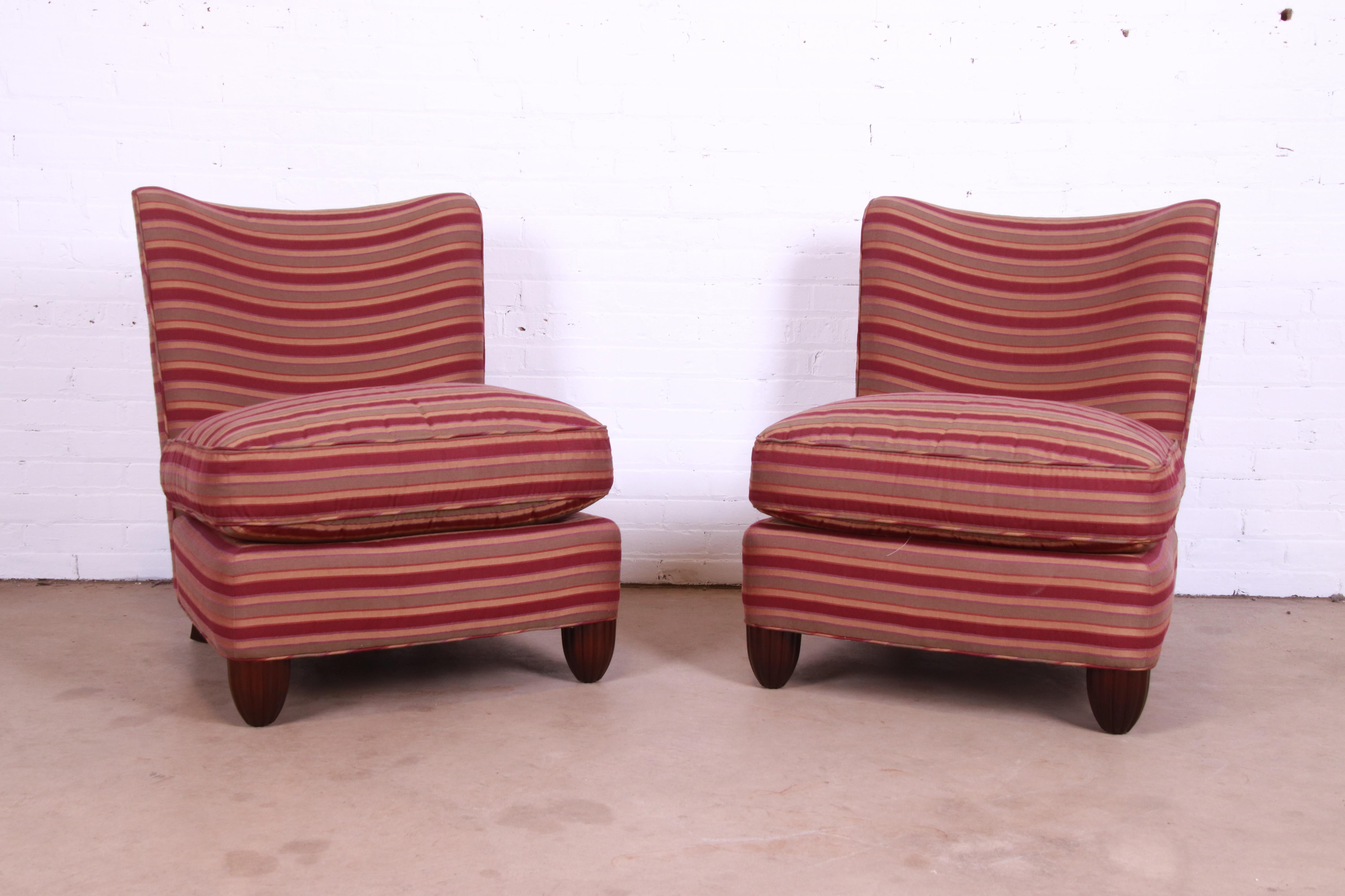 A stylish and comfortable pair of modern upholstered slipper chairs or lounge chairs

By Barbara Barry for Baker Furniture

USA, Late 20th Century

Striped upholstery, with carved mahogany feet.

Measures: 28.5