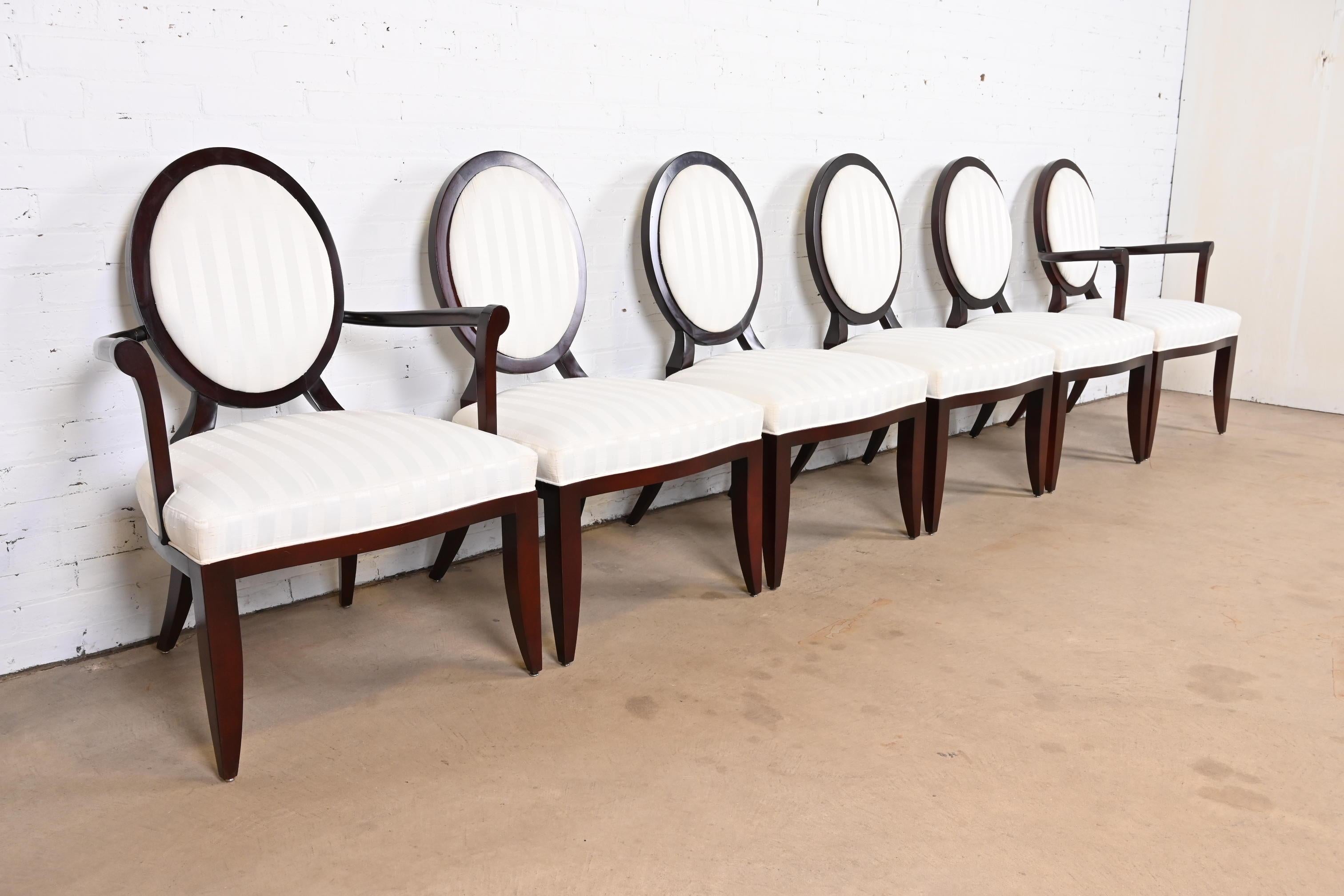 A gorgeous set of six modern Neoclassical style oval back dining chairs

By Barbara Barry for Baker Furniture.

USA, Circa 1990s

Sculpted mahogany, with ivory upholstered seats and backs.

Measures:
Side chairs - 23