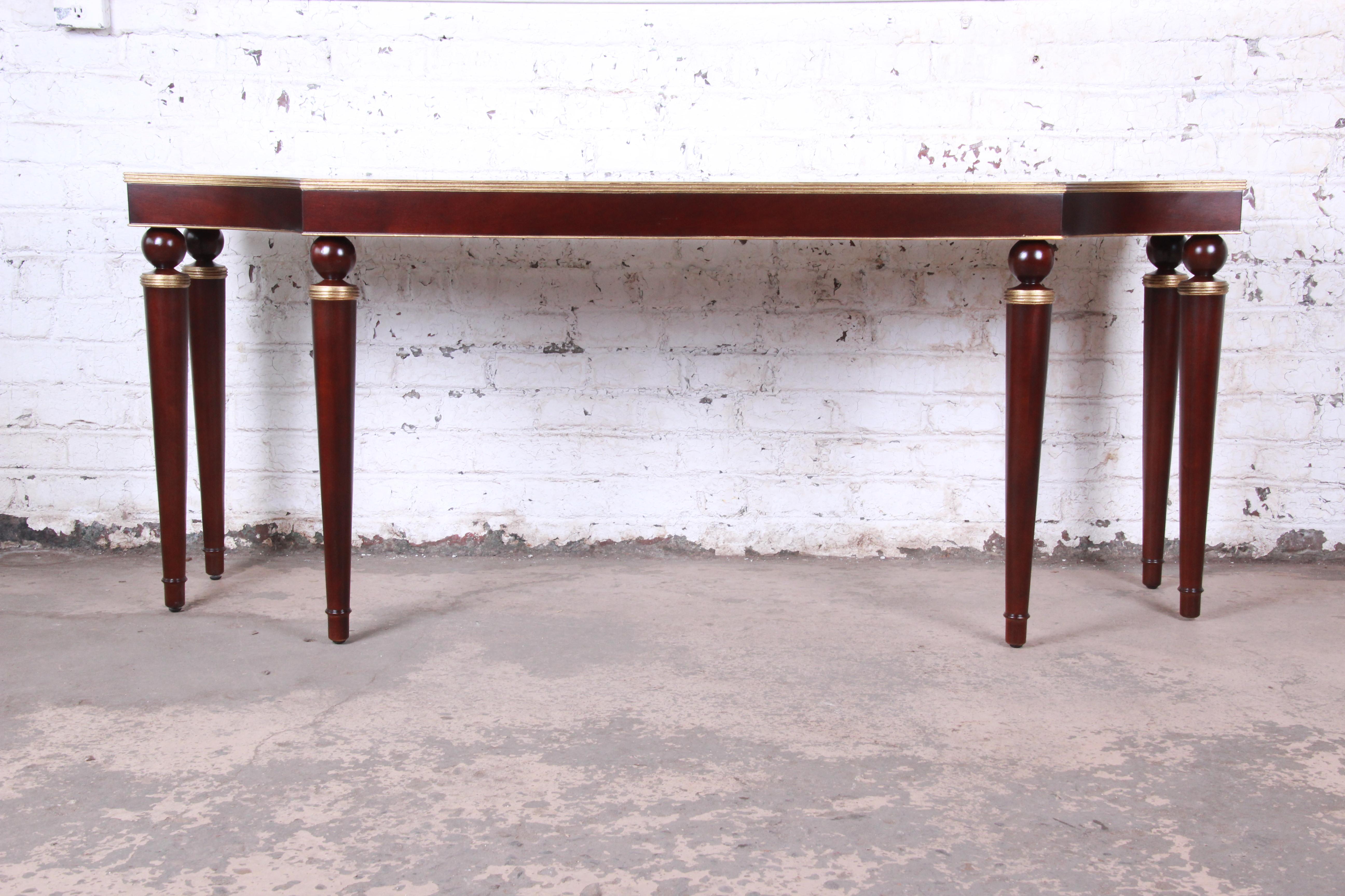 An exceptional monumental modern console or sofa table

Designed by Barbara Barry for Baker Furniture

USA, circa 1990s

Mahogany and gold gilt trim

Measures: 84