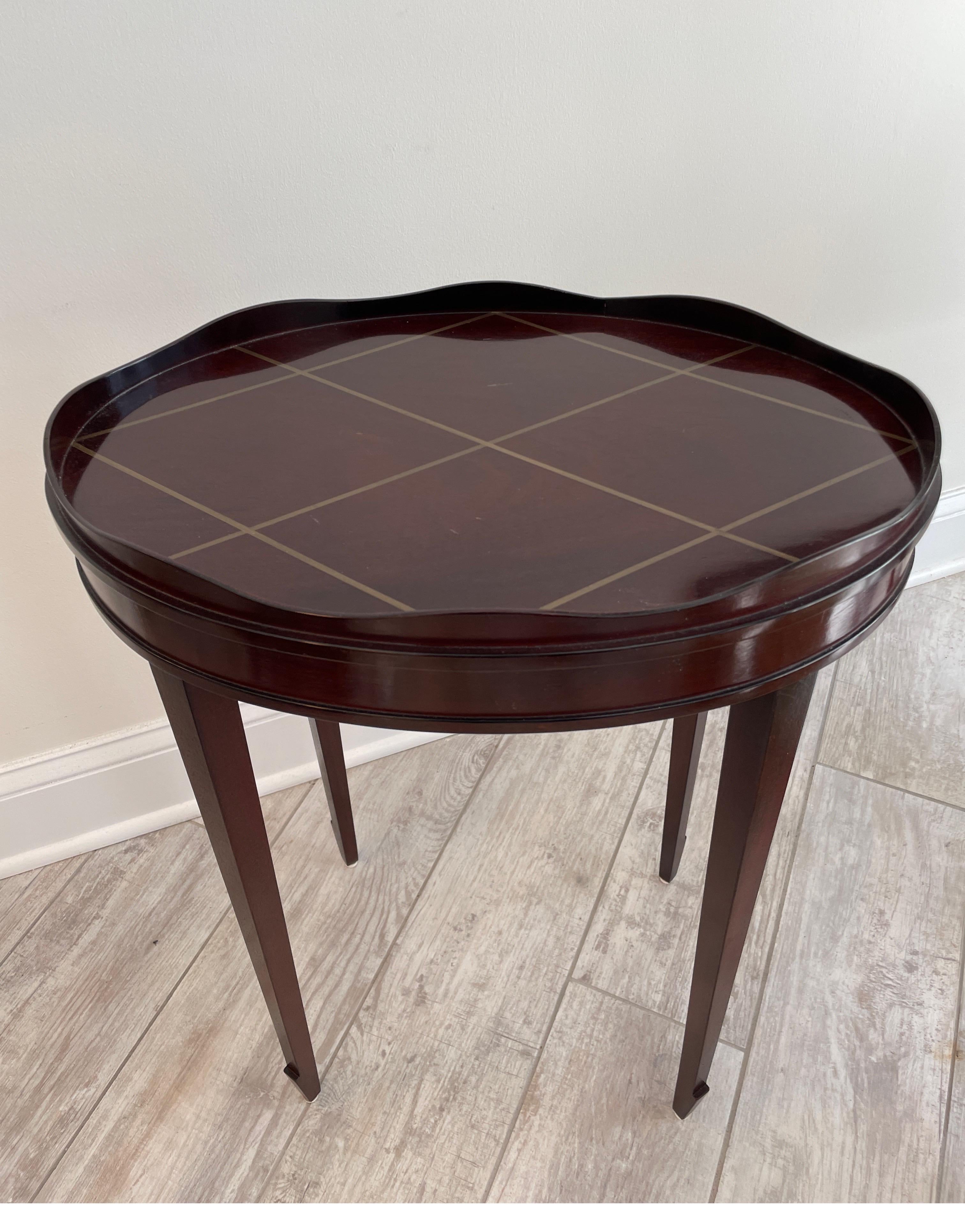 Diminutive oval gallery edge side table by Barbara Barry for Baker. Dark finish with a muted gold lattice detail on top.