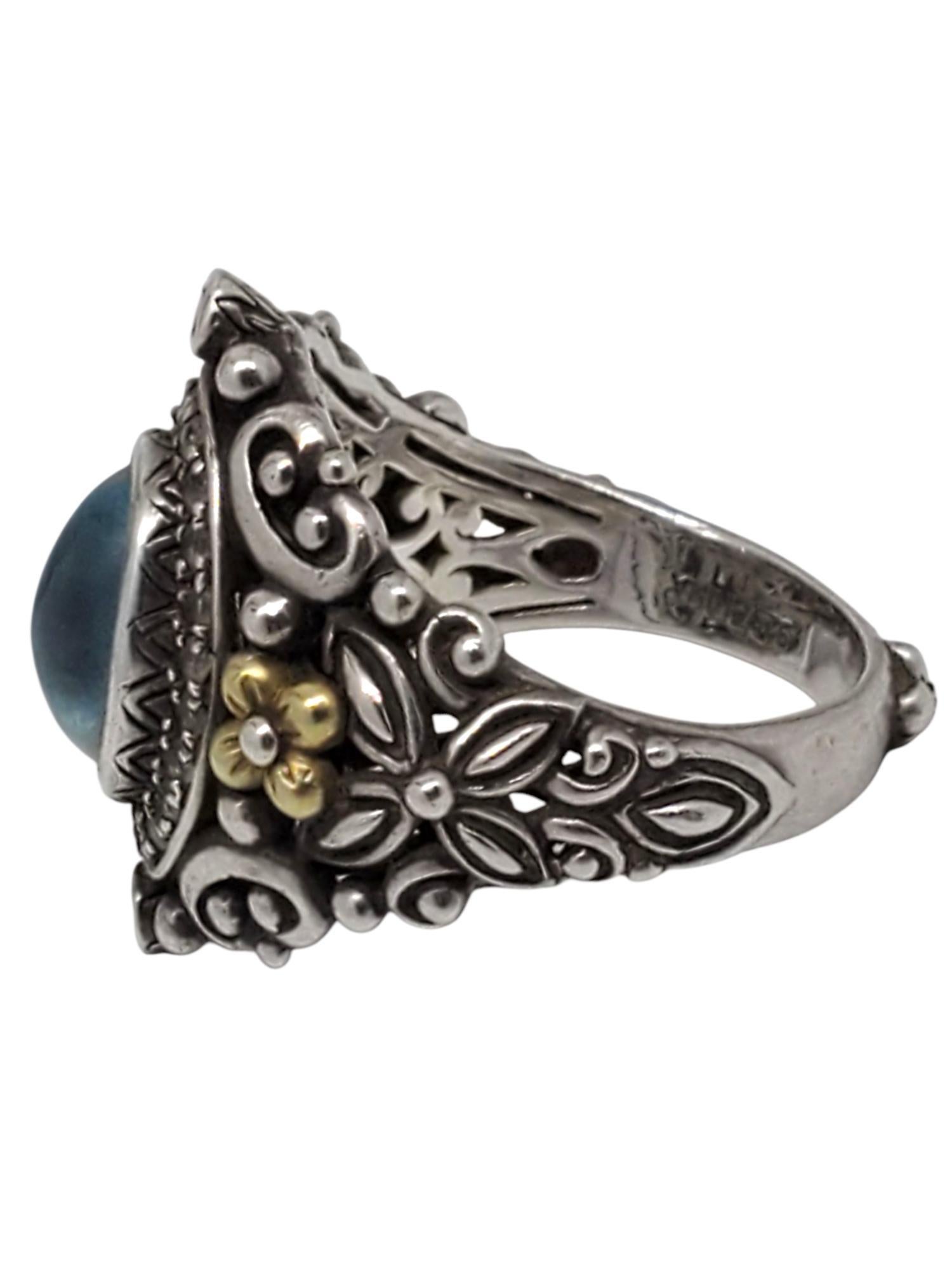 Anello Shangri La di Barbara Bixby in argento sterling e oro giallo 18 carati con topazio 

Questo bellissimo anello Shangri-La di Barbara Bixby presenta un topazio blu ovale (10,4 mm x 8,3 mm) cabochon con gemme di topazio bianco incastonate in un