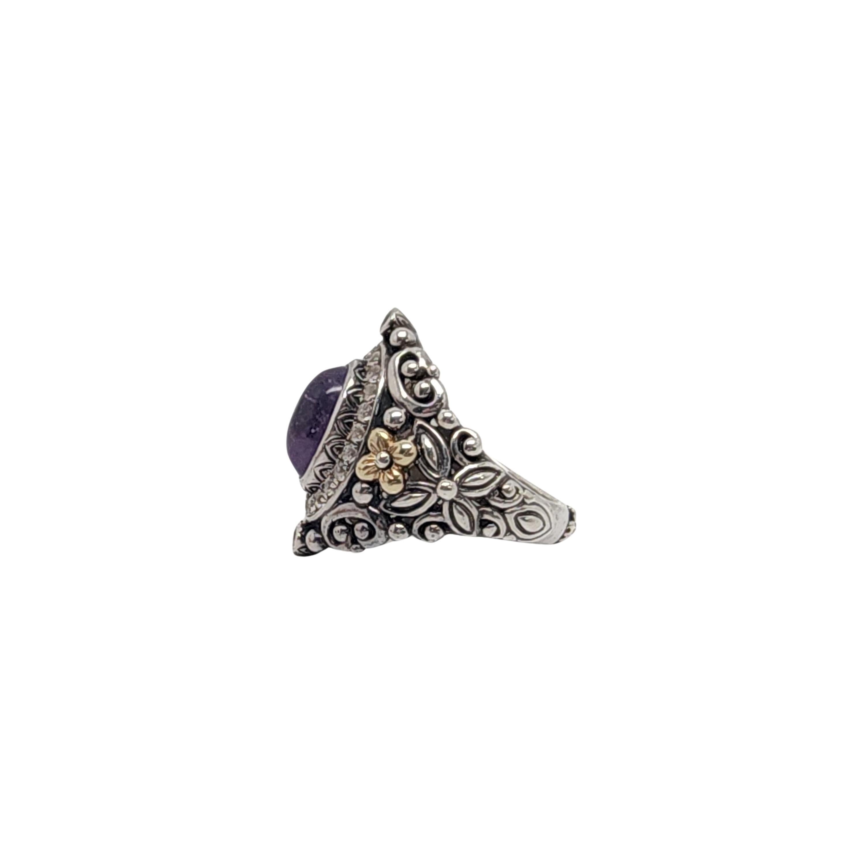 Ring aus Sterlingsilber und 18 Karat Gelbgold mit lila Amethysten von Barbara Bixby.

Größe 8

Dieser Ring ist mit einem ovalen lila Amethyst-Cabochon besetzt, der von runden weißen Topas-Steinen und gelbgoldenen Blumenakzenten an den Schultern