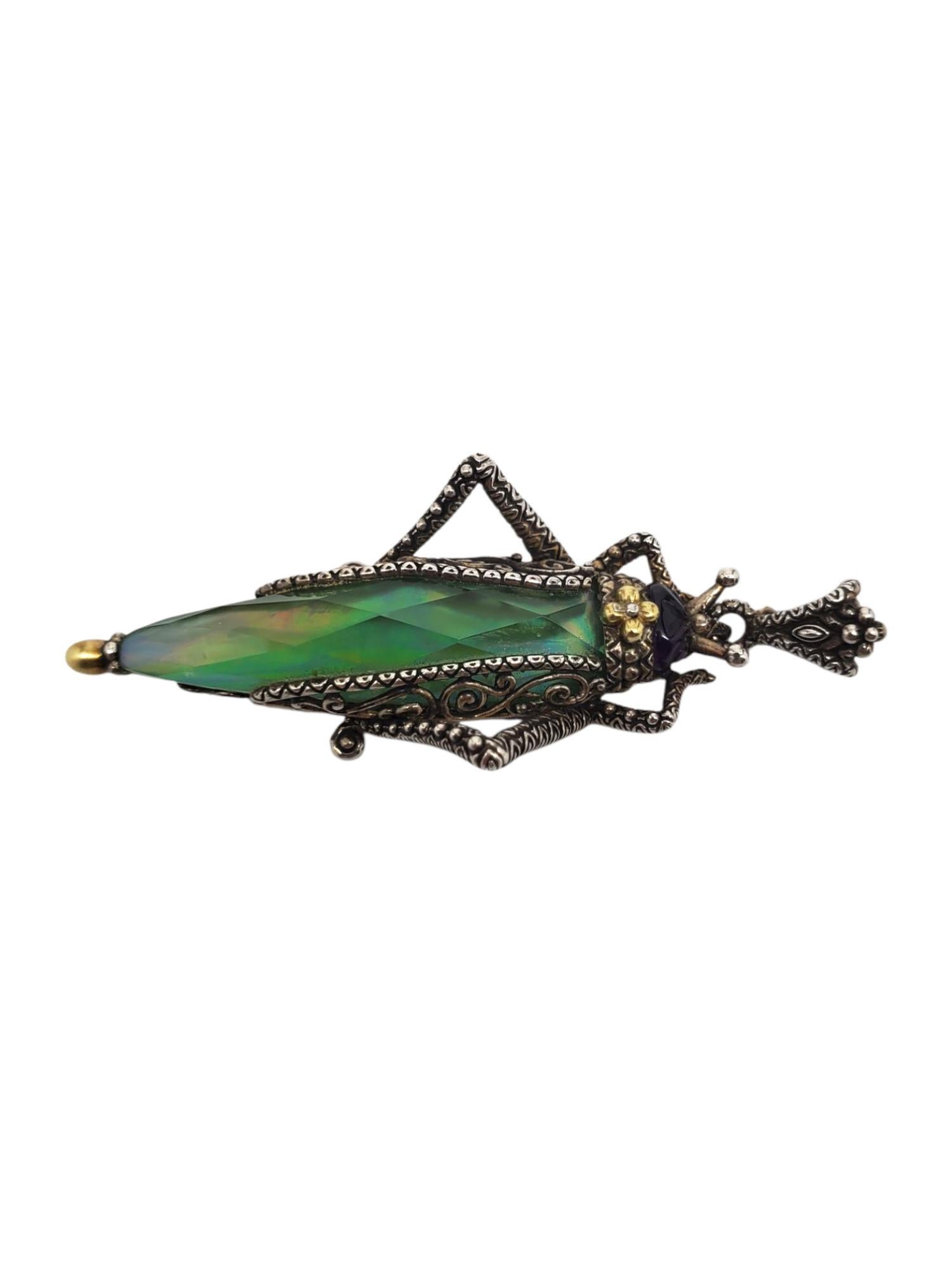 This unique grasshopper pendant by Barbara Bixby features a large lemon quartz (42.53 mm x 13.87 mm) and a carved cabochon amethyst head set in sterling silver and 18kt. gold accents.

Size : 71.38 mm with enhancer
           27mm at