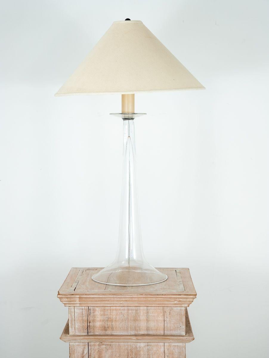 This discontinued Baraba Cosgrove mid-century modern tall table lamp exudes elegance and style. Its glass base, beautifully designed as an ode to the trumpet, captures the essence of musical inspiration. The sleek lines and refined craftsmanship