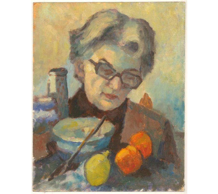 A peaceful and intimate portrait showing a woman with reading glasses, reading something. Fruit and cooking utensils lie on the table in front of her. The artist has used a soft directional light and a close vignette to capture a moment of