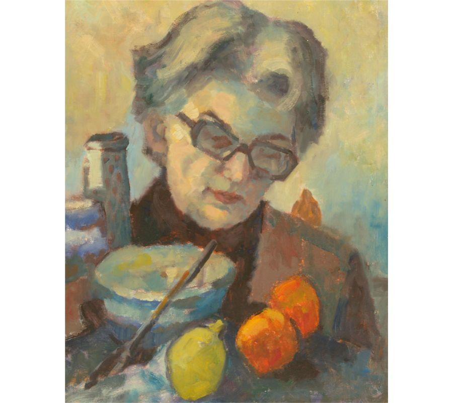 Ein ruhiges und intimes Porträt, das eine Frau mit Lesebrille zeigt, die etwas liest. Obst und Kochutensilien liegen vor ihr auf dem Tisch. Der Künstler hat ein weiches, gerichtetes Licht und eine enge Vignette verwendet, um einen Moment der