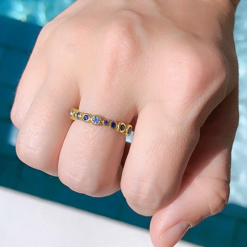 Bubble Band Ring handcrafted by award winning jewelry maker Barbara Heinrich in matte-finished and high-polished 18k yellow gold featuring 1.21 total carats of assorted blue sapphires in multiple tones. Size 7.5. Stamped and Hallmarked.

About the
