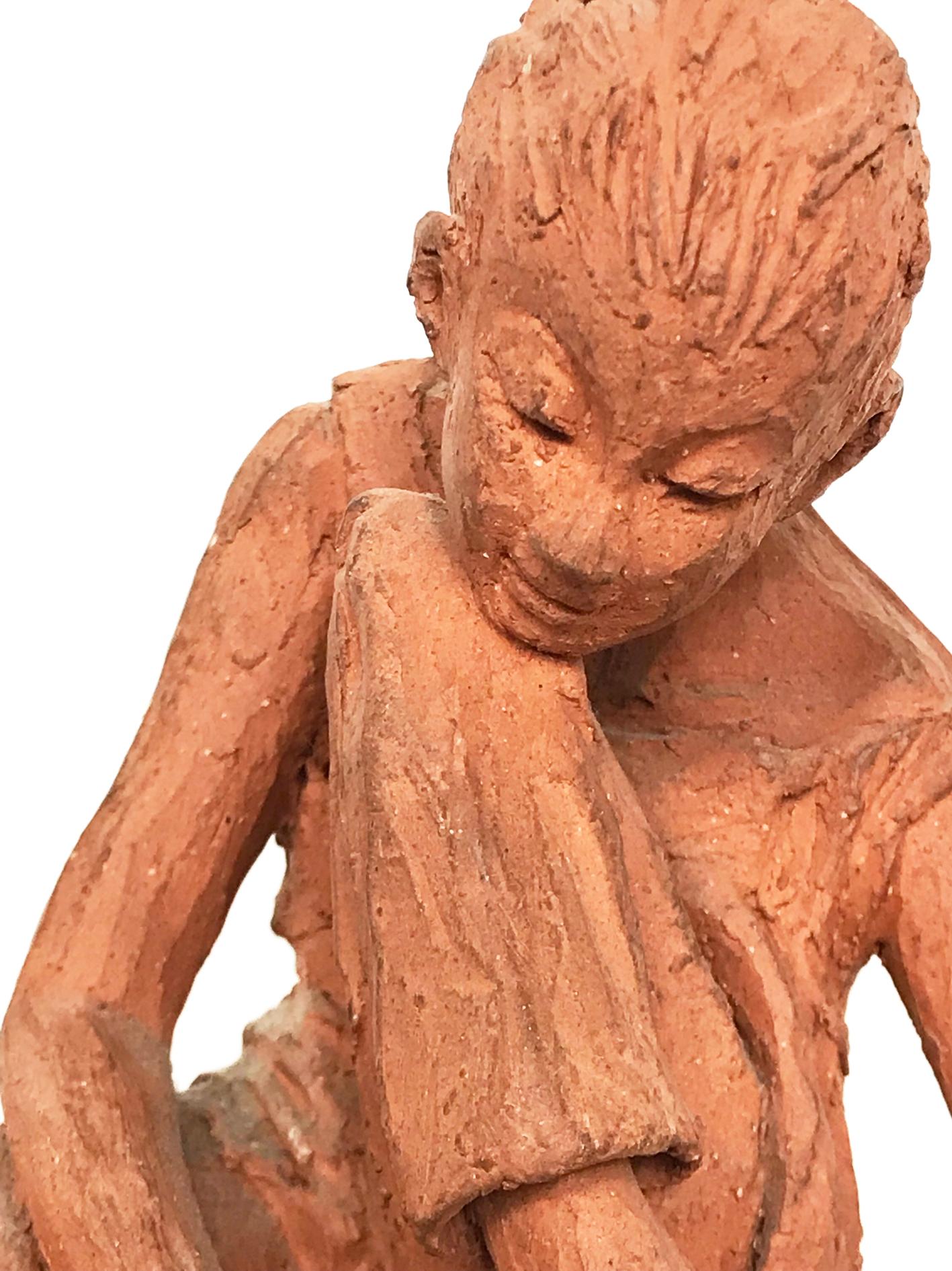 Charming study of a young girl putting on her shoe. Hand made in terracotta on a beech base by Barbara Hughes. Label to base.