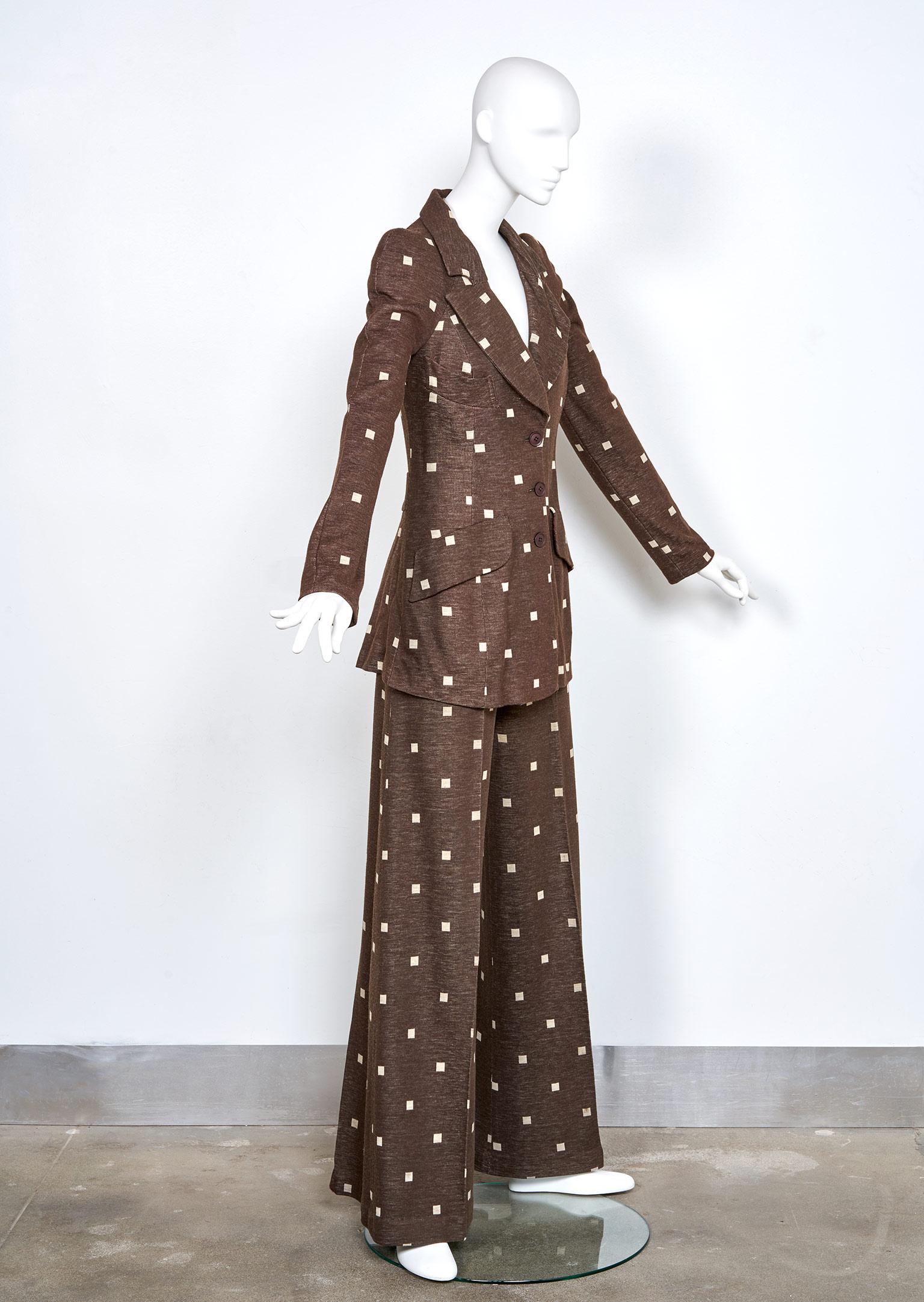 When Barbara Hulanicki launched the concept of the bell bottom Power Suit in her Biba London boutique, sales went off the charts. Offered here, an iconic example in heathery chocolate brown, imbued with contrasting creme mod square motif.