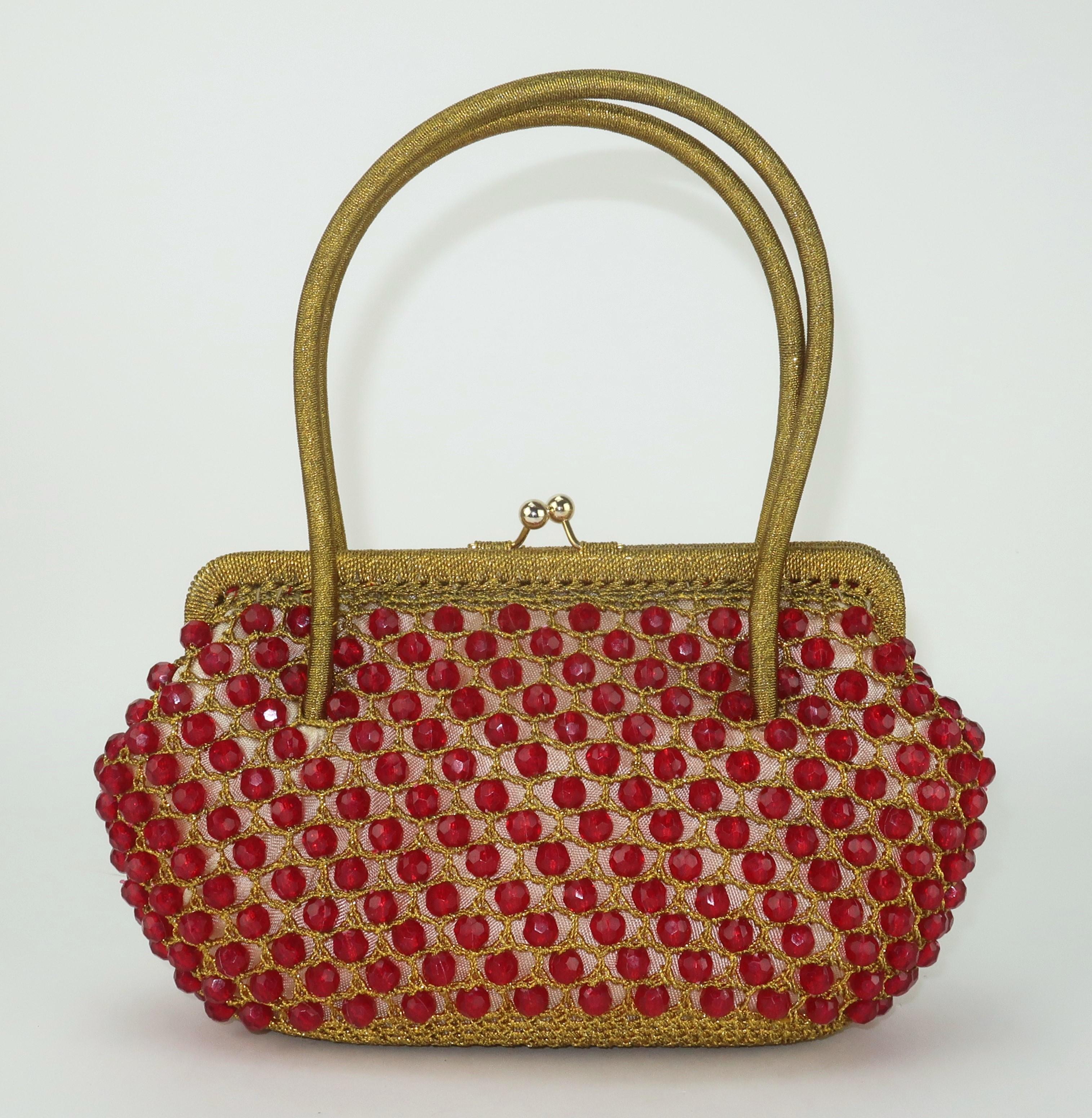 1960's Italian made Barbara Lee gold crochet handbag embellished with ruby red faceted beads.  The double top handle bag features a kiss lock closure which opens to reveal a red satin lined interior.  This precious bauble is a wonderful accessory