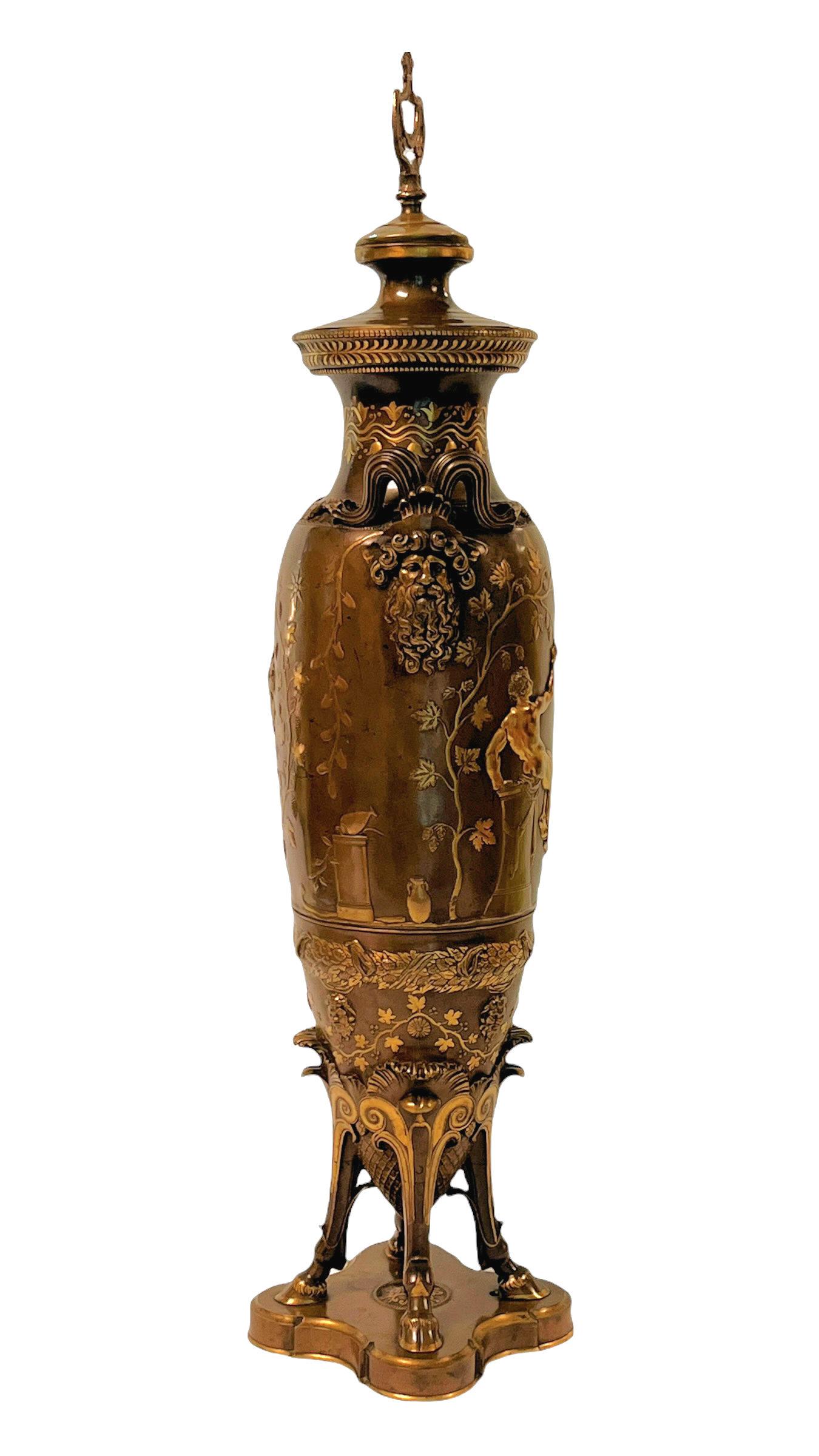 Our partially gilt bronze vase from Barbedienne was designed by Ferdinand Levillian (1837-1905), circa 1880s, and features a Roman scene and face of Bacchus on other side.  Drilled for use as a table lamp. Finial at top is missing.  We may add