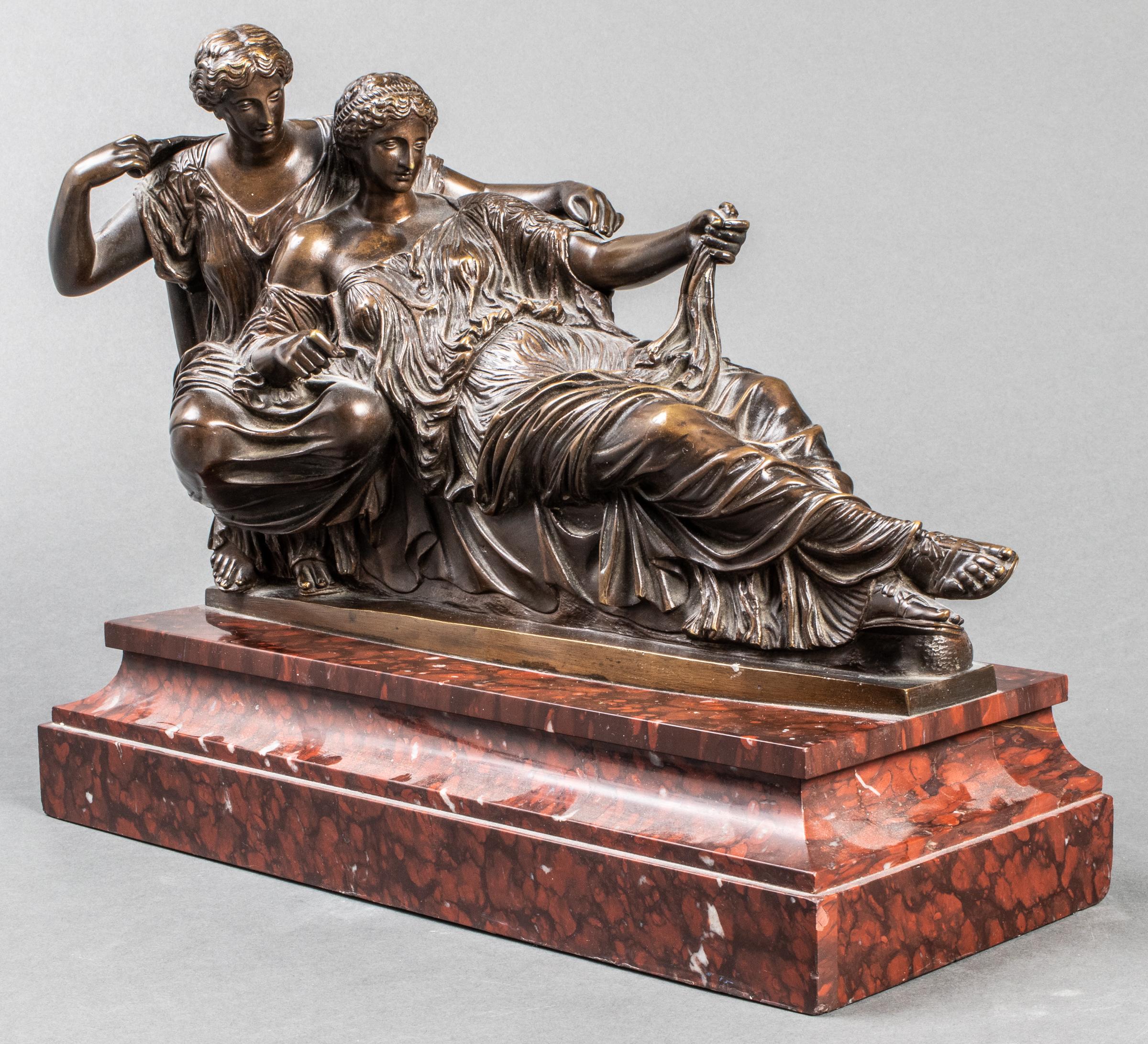 After Ferdinand Barbedienne (French 1810-1892) patinated bronze model of two Classical Muses depicted in graceful recline and attired in Ionic chiton tunics, unsigned, mounted on a stepped red marble base, probably Rosso Barocco.
Barbedienne
