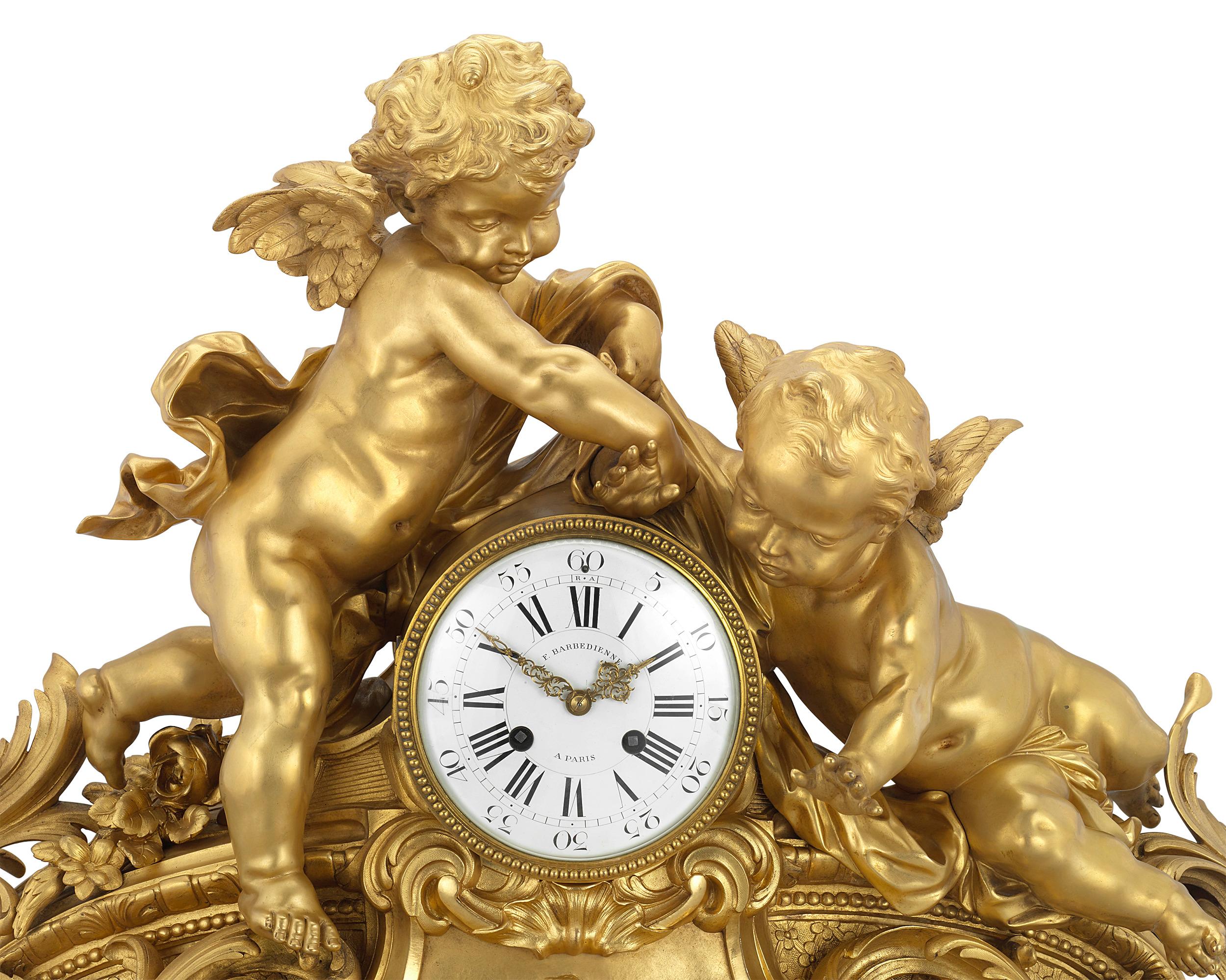 This spectacular gilt bronze mantel clock was expertly crafted by the celebrated French bronzeur Ferdinand Barbedienne. Designed in the extravagant Louis XV style, the timepiece is a tour-de-force of the Rococo manner. Sweeping scrolls and acanthus