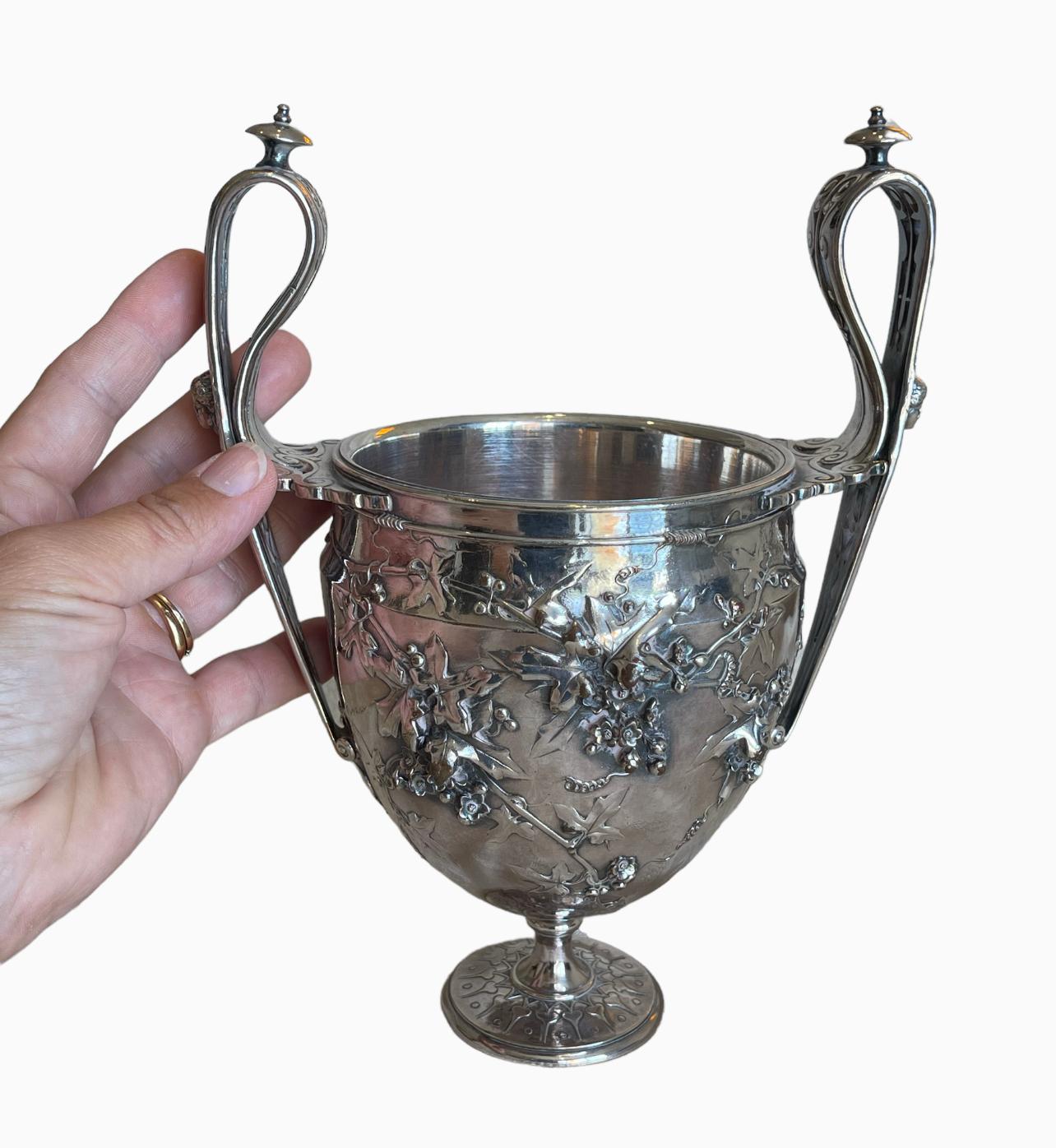 Vase à anses ou coupe kantharos en bronze argenté ciselé et ajouré réalisé en 1866 par le fondeur Ferdinand Barbedienne. Modèle créé par le sculpteur Louis Constant Sevin et sculpture réalisée par Désiré Attarge.
Ce gobelet est en très bon