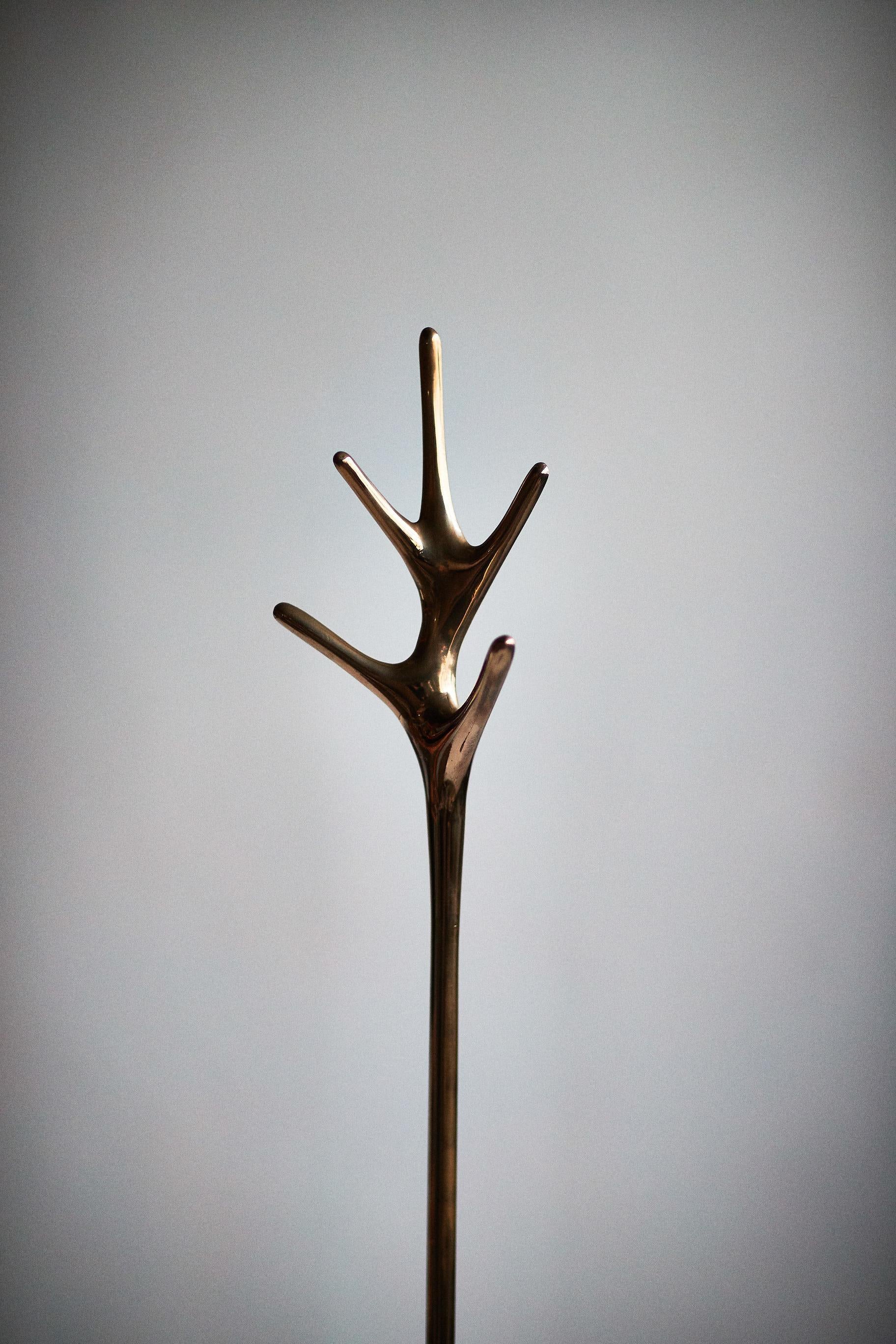 Conçue par Daniel Barbera, la lampe Lovelock est fabriquée à partir d'une base en bronze massif coulé au sable et finie à la main pour obtenir un poli miroir lisse, avec l'option d'un bronze satiné ou noirci. Sculptural et minimal, ce porte-manteau