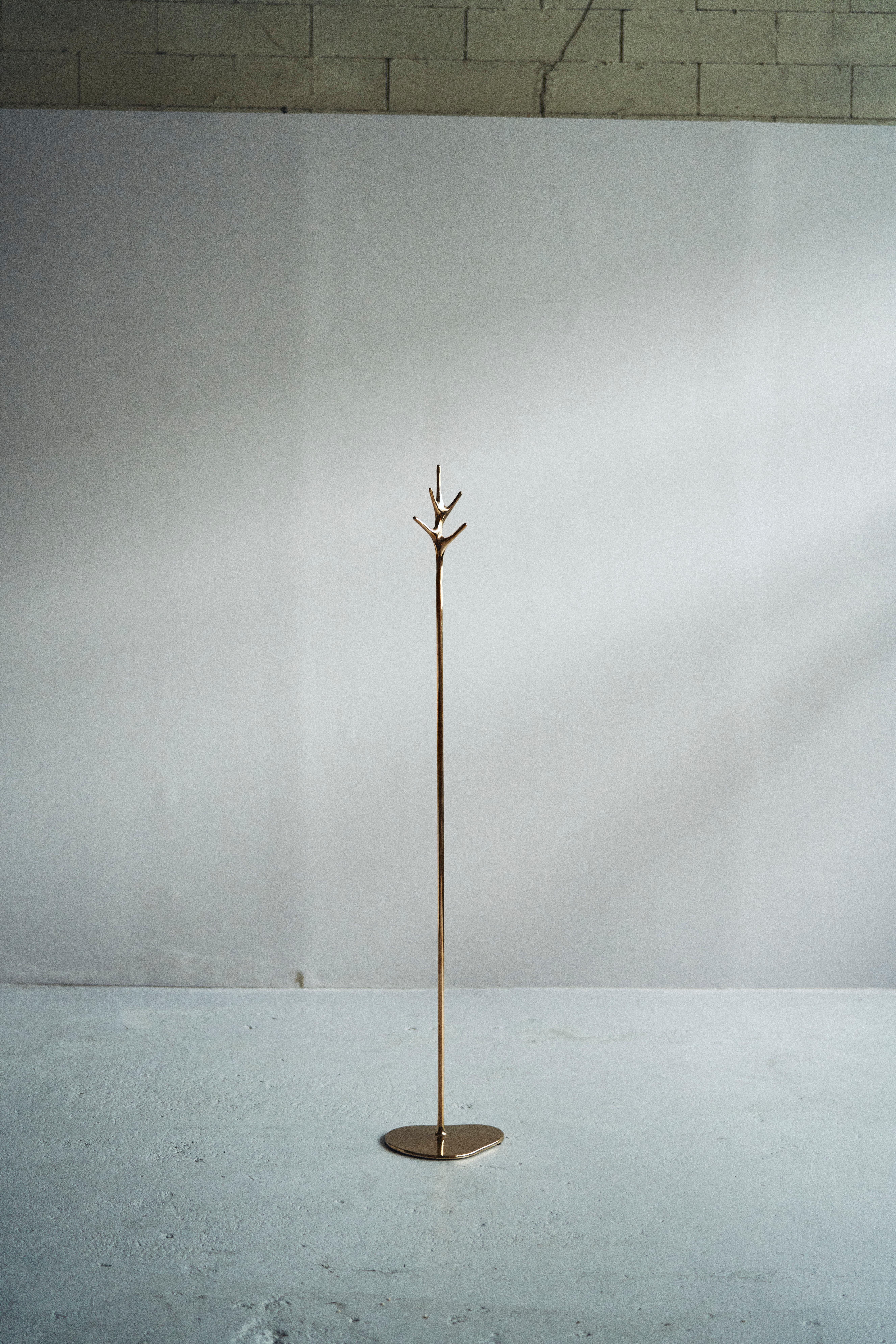 The 'Lovelock' coat stand is a stunning piece of art that combines elegance and utility. It was created by Daniel Barbera, a renowned designer who specializes in sandcasting techniques. The base of the coat stand is made from solid bronze that is