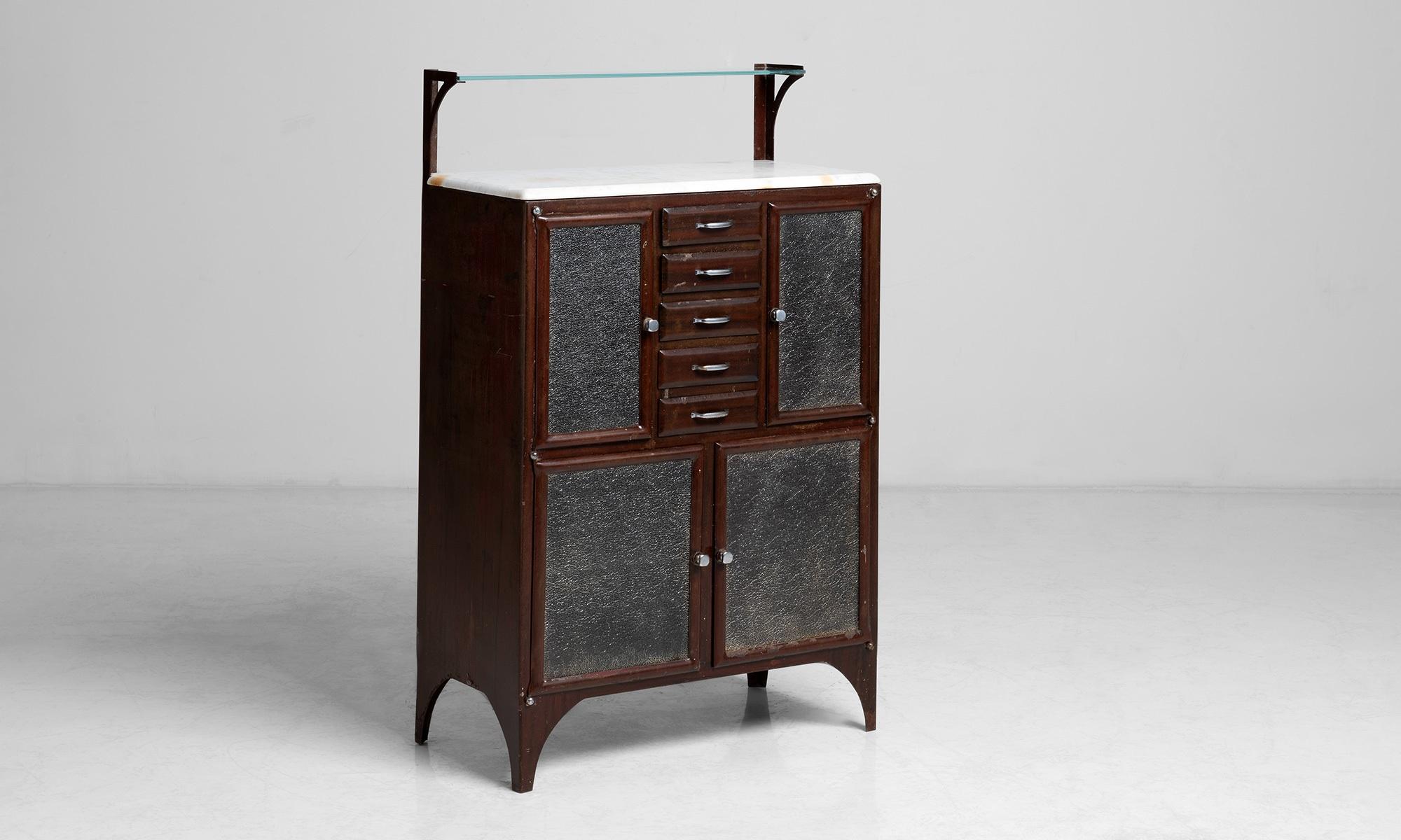 Barbers cabinet.

England circa 1920.

Barbers cabinet composed of mahogany with a marble top and textured glass doors and upper glass shelf.

Measures: 31.5”W x 17”D x 51.5”H.
 