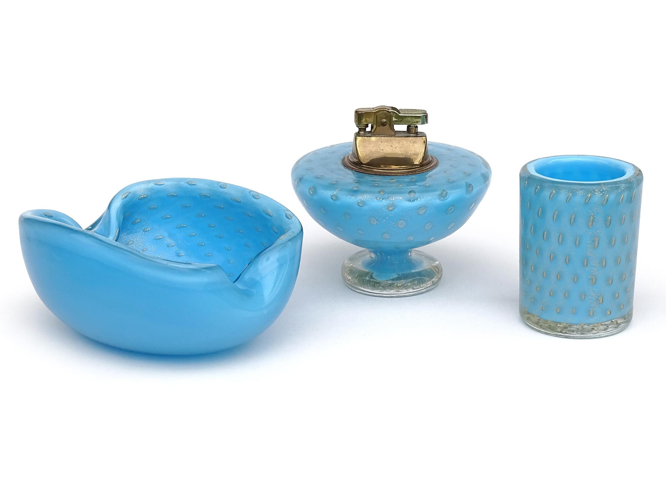 Beautiful vintage Murano hand blown blue, controlled bubbles and gold flecks Italian art glass ashtray / vide poche, lighter and cigarette holder. Documented to designer Alfredo Barbini, circa 1950s. The set is published in his Weil Ceramics and