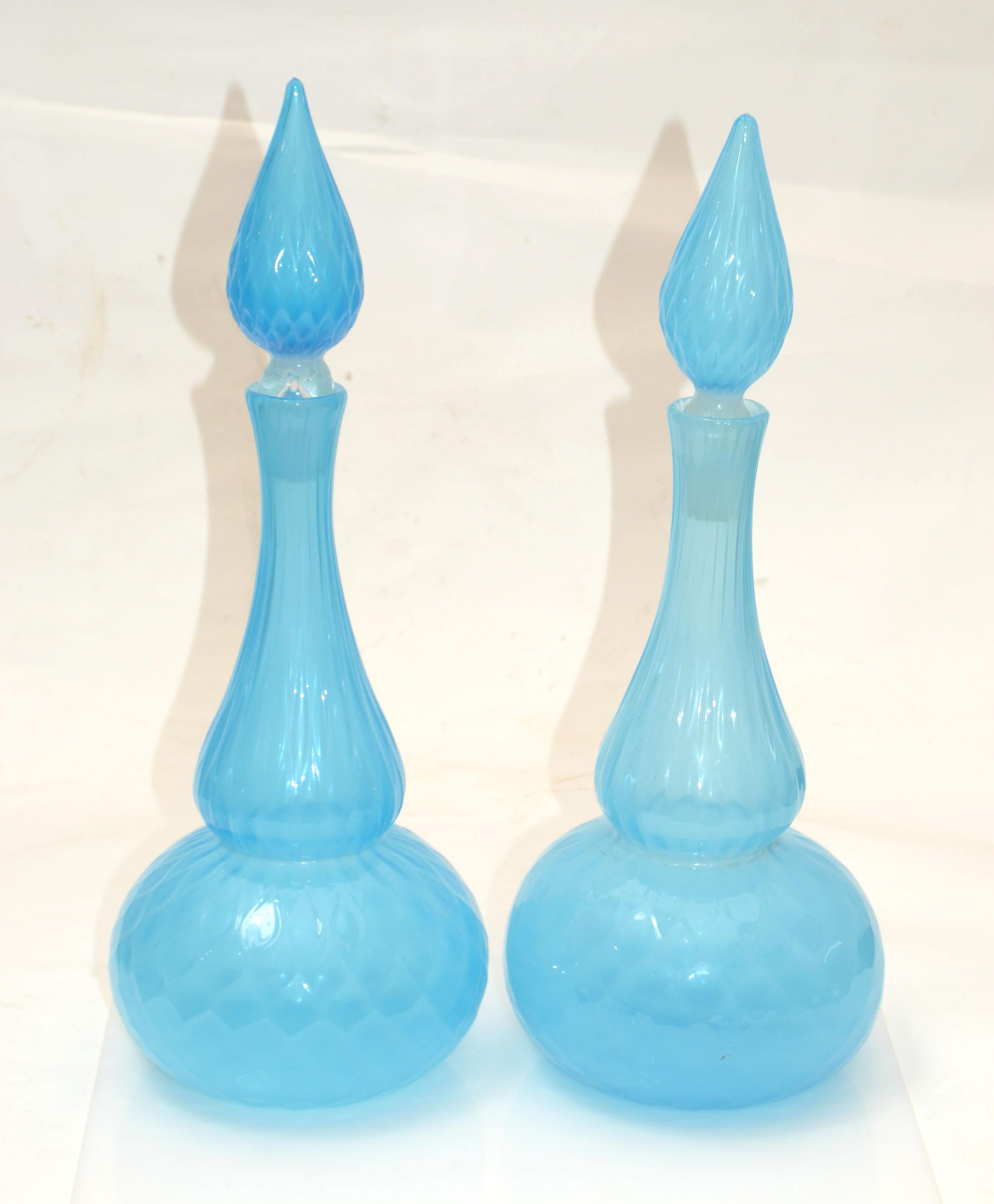 Stunning Pair of Mid-Century Modern Decanter or Vessel made out of blown faceted Murano Art Glass in light blue and stopper by Barbini, Italy.
A gorgeous addition for your holiday table settings.

 