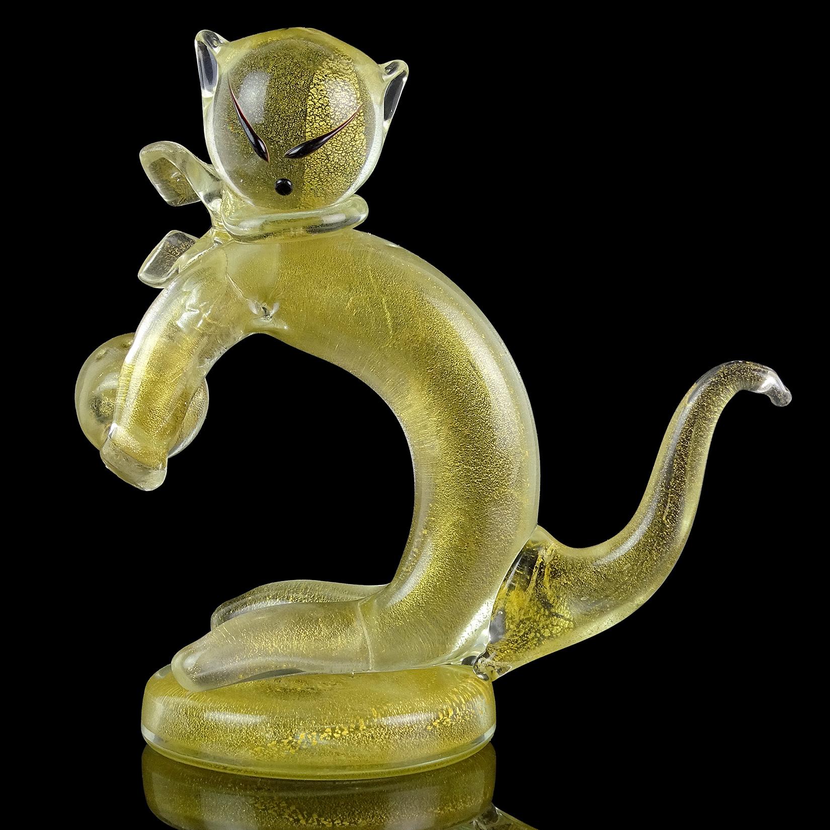 Super cute and rare, vintage Murano hand blown gold flecks Italian art glass kitty cat figurine / sculpture. Attributed to designer Alfredo Barbini. The piece is very unusual, with a kitten playing with a ball. It has black accents on his face for