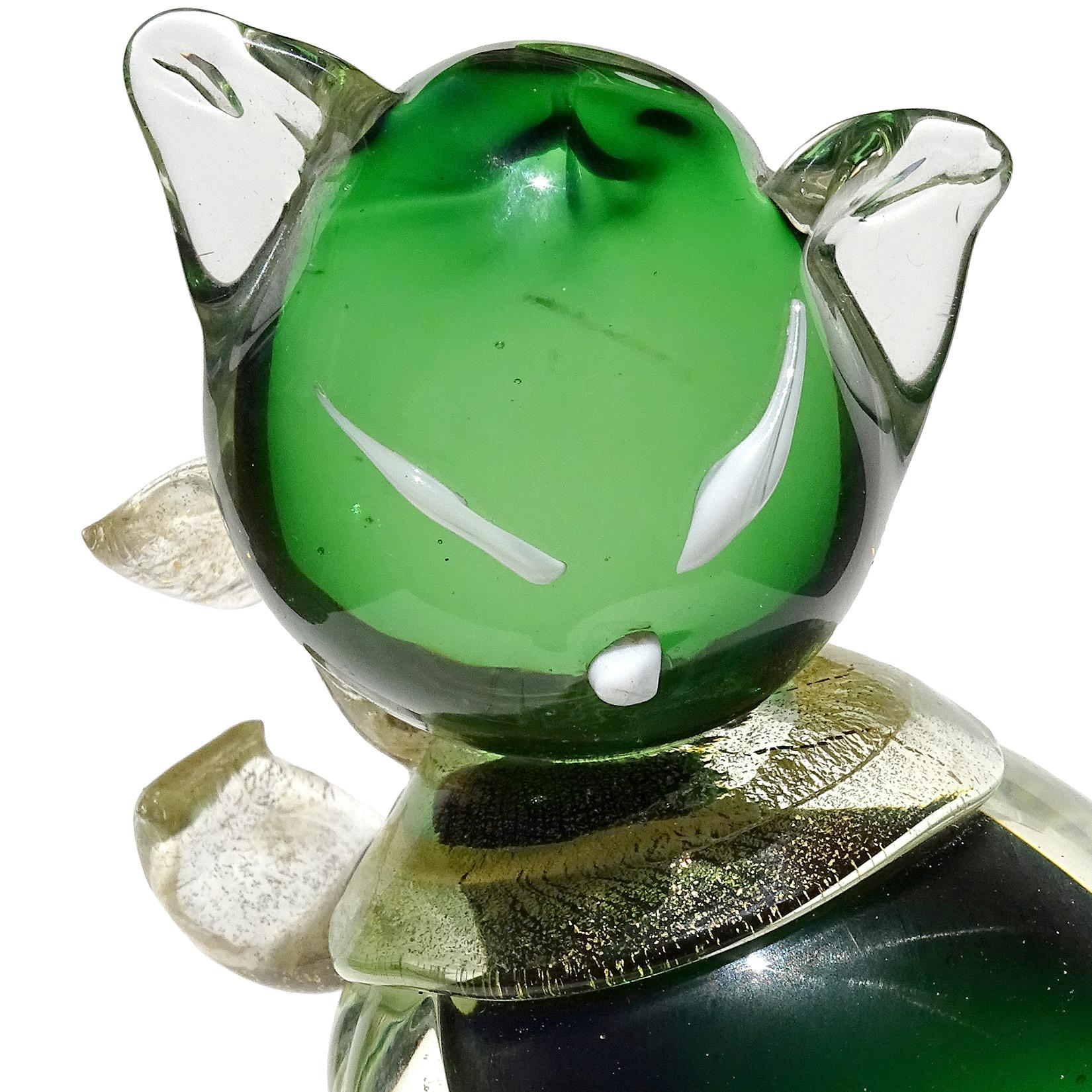 Beautiful Murano hand blown Sommerso green and gold flecks Italian art glass kitty cat sculpture on round base. Attributed to designer Alfredo Barbini. The piece has a gold leaf bow around its neck, gold tail and white eyes and nose. Stands on a