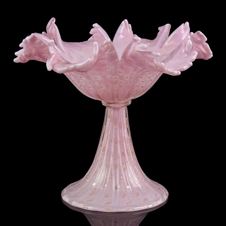 Beautiful vintage Murano hand blown pink, bubbles and gold flecks Italian art glass pedestal compote bowl. Documented to designer Alfredo Barbini for Salviati, circa 1950s. The bowl has a scissor cut rim, creating a flower shape. Created in the