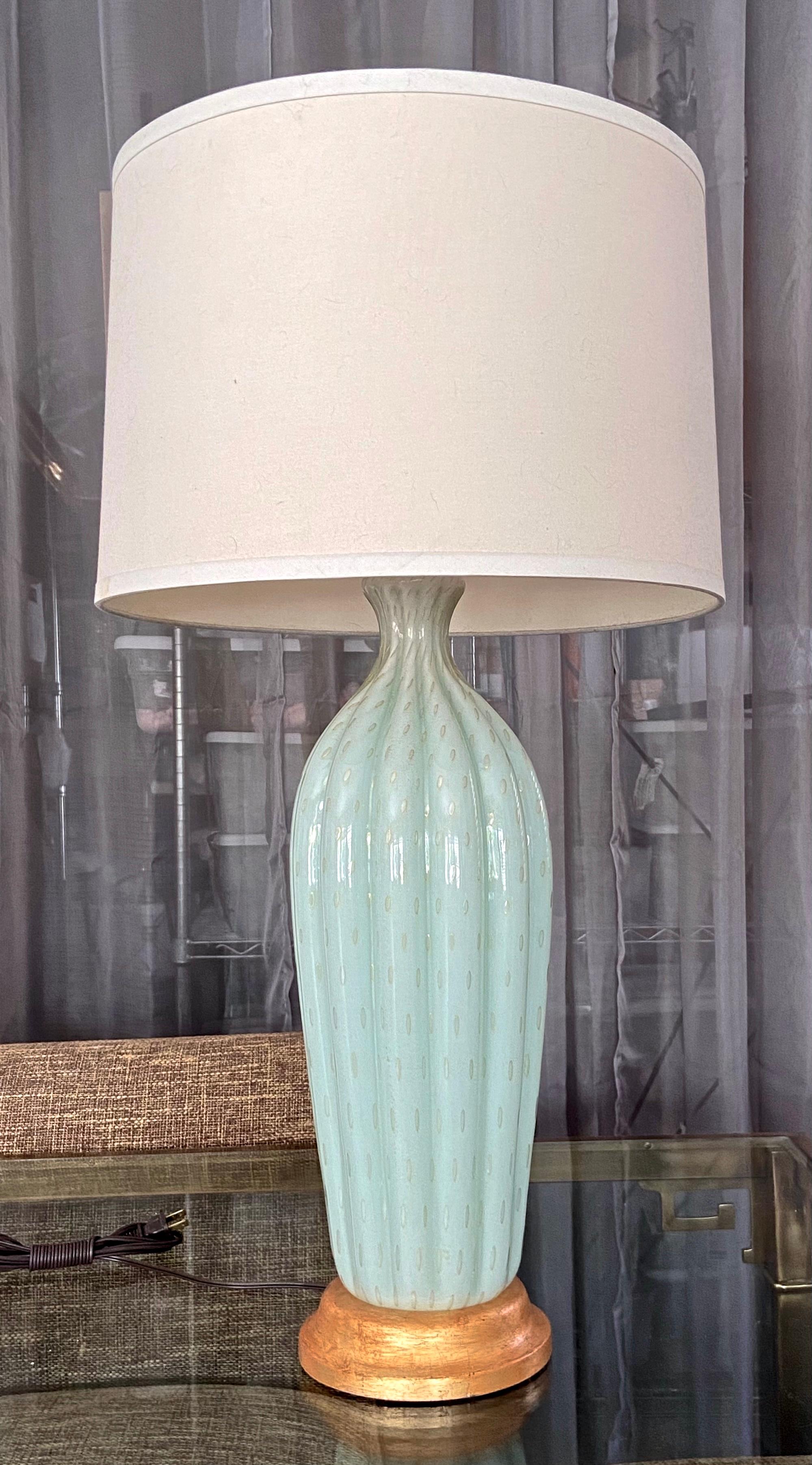 Tall Murano Italian handblown seafoam green colored glass table lamp by Alfredo Barbini. The lamp has vertical ribs with controlled gold bubbles throughout, resting on an antiqued giltwood base. Newly wired with new 3 way brass socket and fittings.