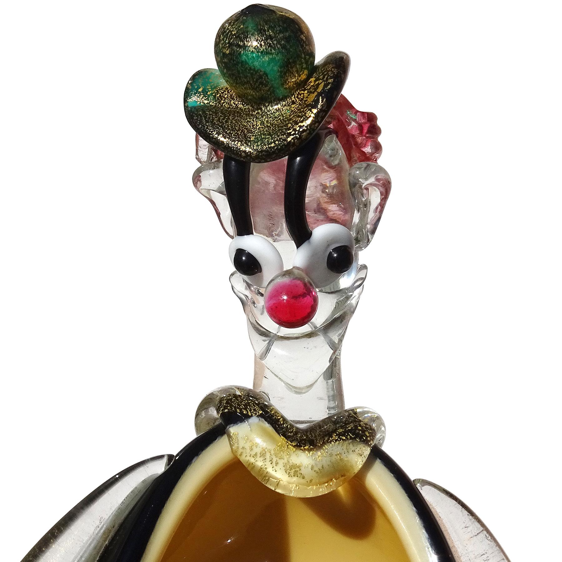 Beautiful and cute, vintage Murano hand blown black and orange with gold flecks accents Italian art glass clown sculpture and bowl. Attributed to designer Alfredo Barbini, for the Salviati company. The figure has a green hat with gold, pink hair,