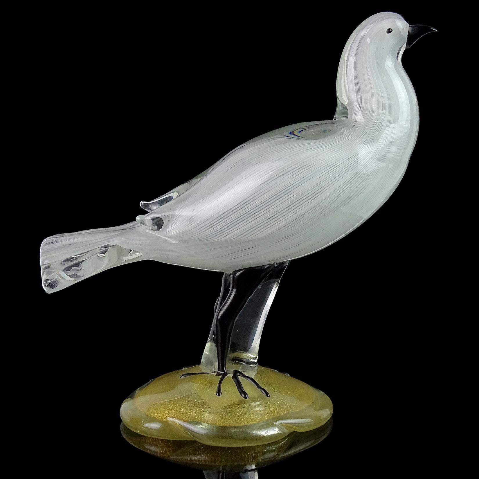 Beautiful vintage Murano hand blown white ribbons art glass bird sculpture with gold flecks base. Documented to designer Alfredo Barbini for the Salviati company. Labelled with an early “Camer Glass - New York - Made In Italy” label. Has applied