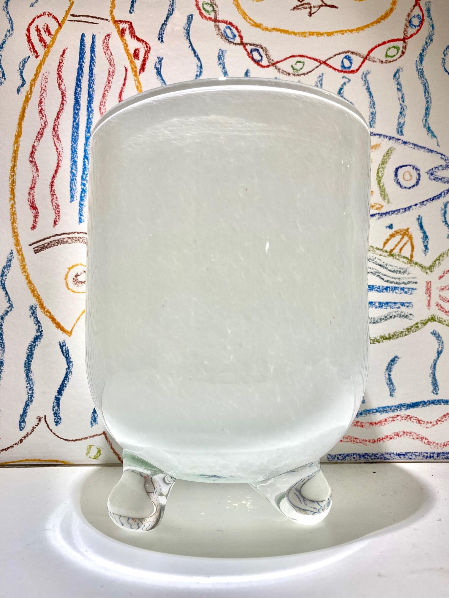 Vintage handblown glass vase with footed base in white opaque glass. The vase has a rounded urn form with Neoclassical / Mid-Century Modern inspired design and features tripod legs in clear blown glass. Makes a great centerpiece. The large diameter