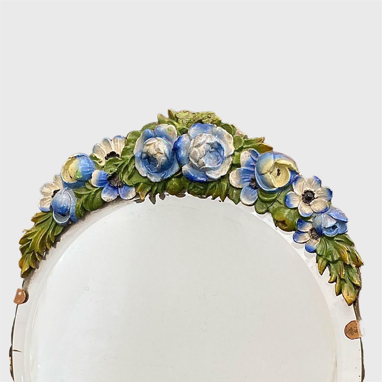 Miroir Barbola avec bord biseauté et motif guirlande de fleurs bleues

Magnifique miroir barbola à bord biseauté, orné d'un motif de guirlandes de fleurs bleues. Le verso est peint en or. Il y a un bras de support pliable.

Le miroir mesure 22,4 cm