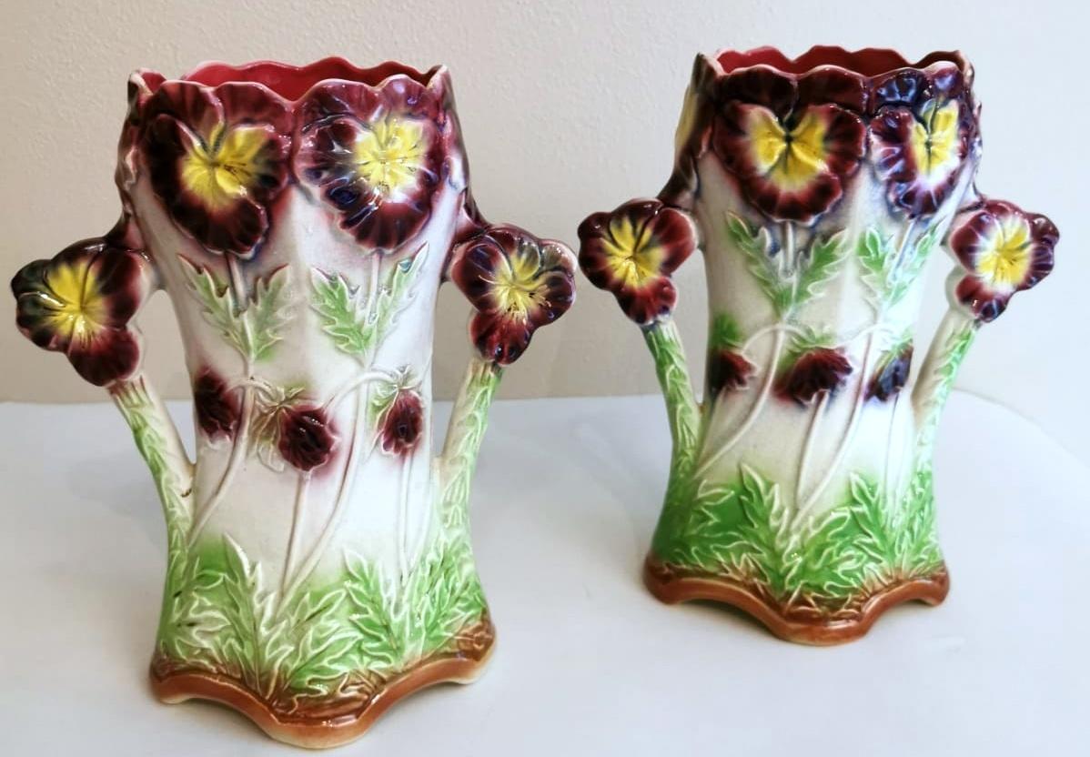 Pair of barbotine ceramic vases; they are beautifully embellished with elaborate hand-painted floral decorations; the handles are very personal and delightful; the shape is unusual and eccentric; the colors are vibrant and the finish is brilliant,