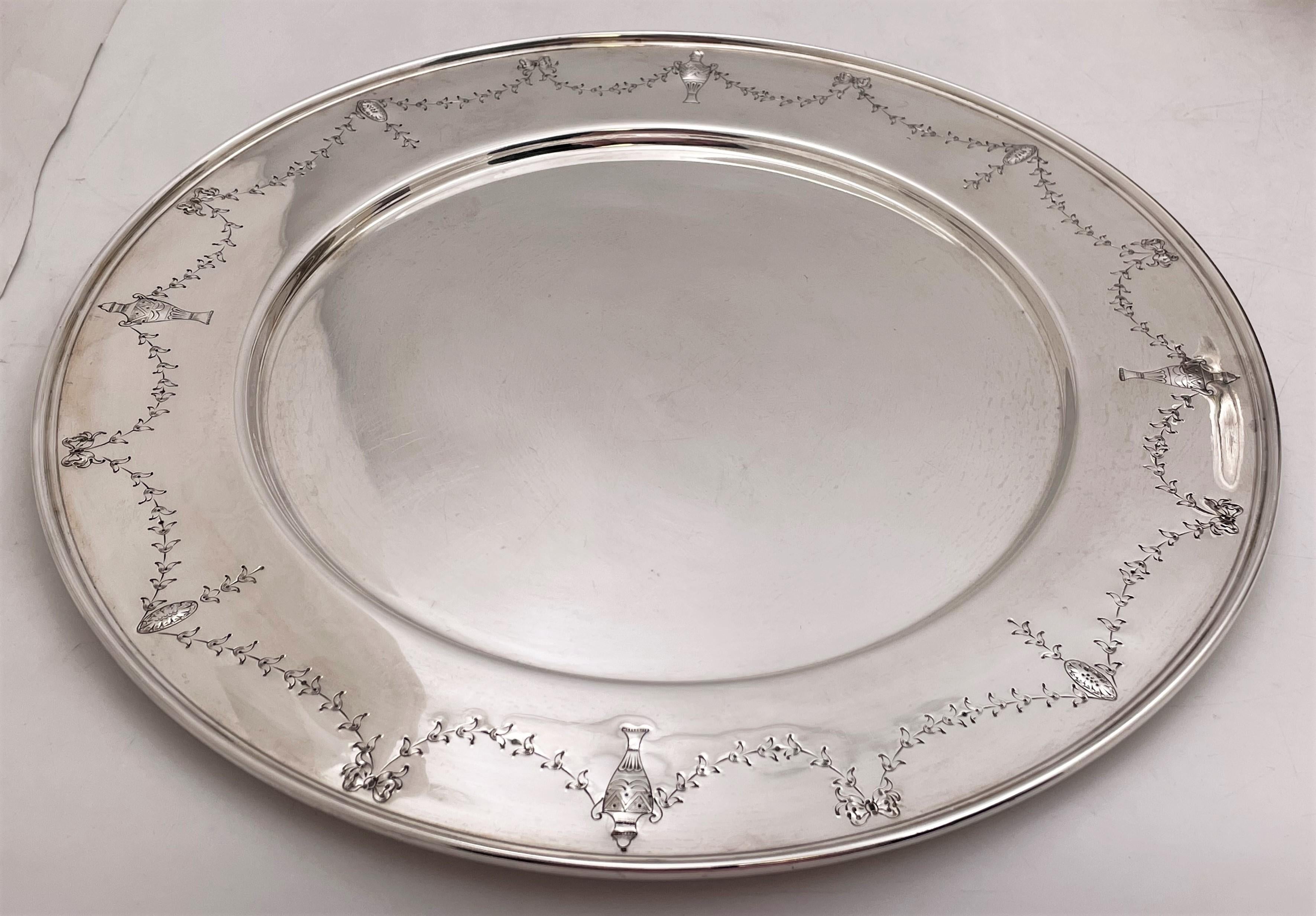 Ensemble de 12 assiettes à dîner ou chargeurs en argent sterling de marque International Sterling/ Barbour & Co. en motif Orange Blossom numéro 1319C du début du 20e siècle. Chacun mesure 12'' de diamètre par 3/8'' de hauteur et porte les poinçons